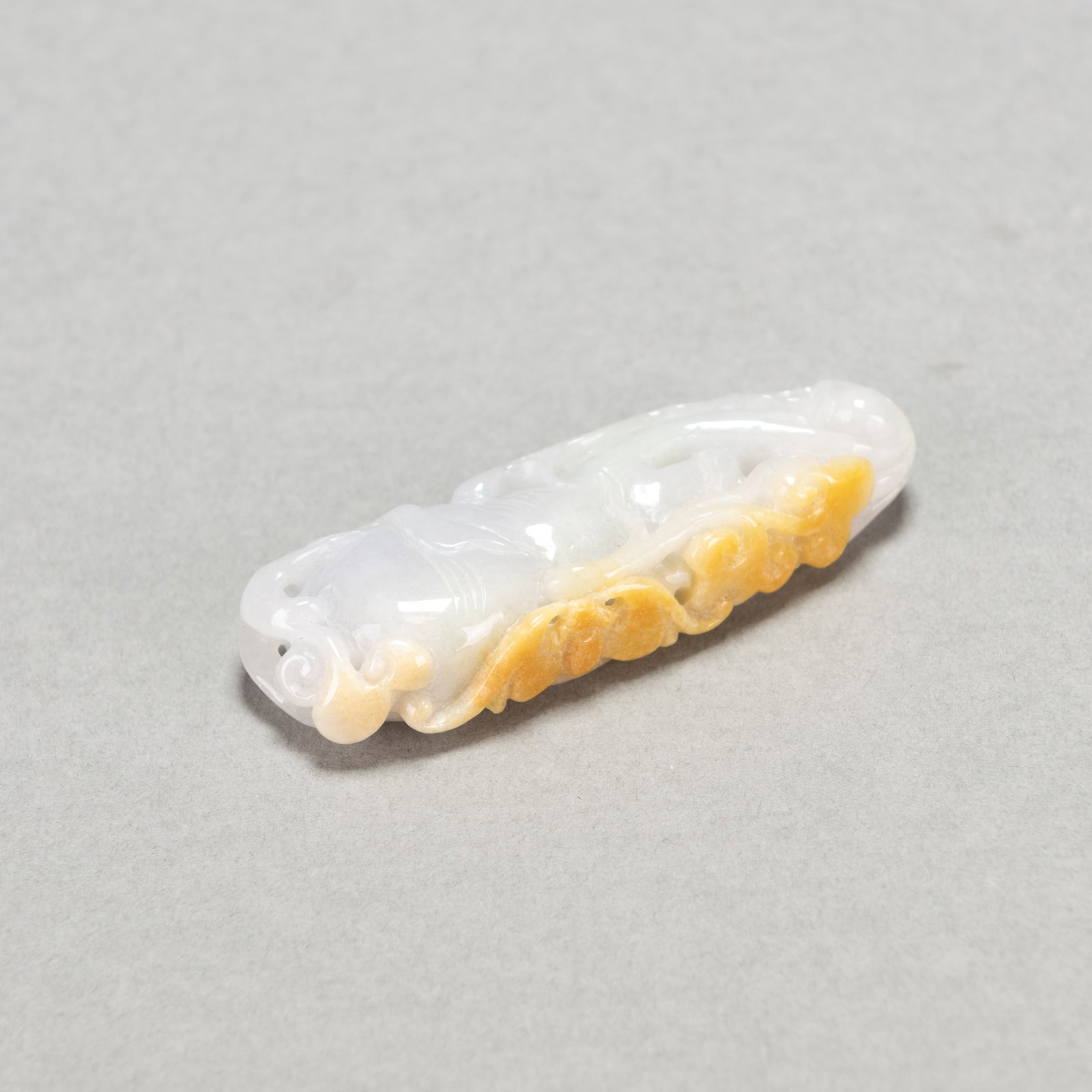CARVED LAVENDER JADEITE PENDANT: Carved lavender jadeite pendant. 0.59"h x 0.98"w x 2.95"l (1.5 x 2.5 x 7.5 cm)