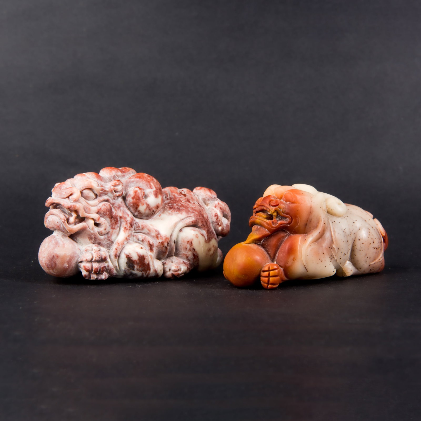 (LOT OF 2) PAIR OF SOAPSTONE PIXIU: (lot of 2) Pair of finely carved soapstone Pixiu holding balls, Chinese mythical beasts symbolizing auspiciousness. 3.5"h x 1.25"w x 1.75"l (8.89 x 3.18 x 4.45 cm); 3"h x 1"w x 1.25"l (7.62 x 2.54 x 3