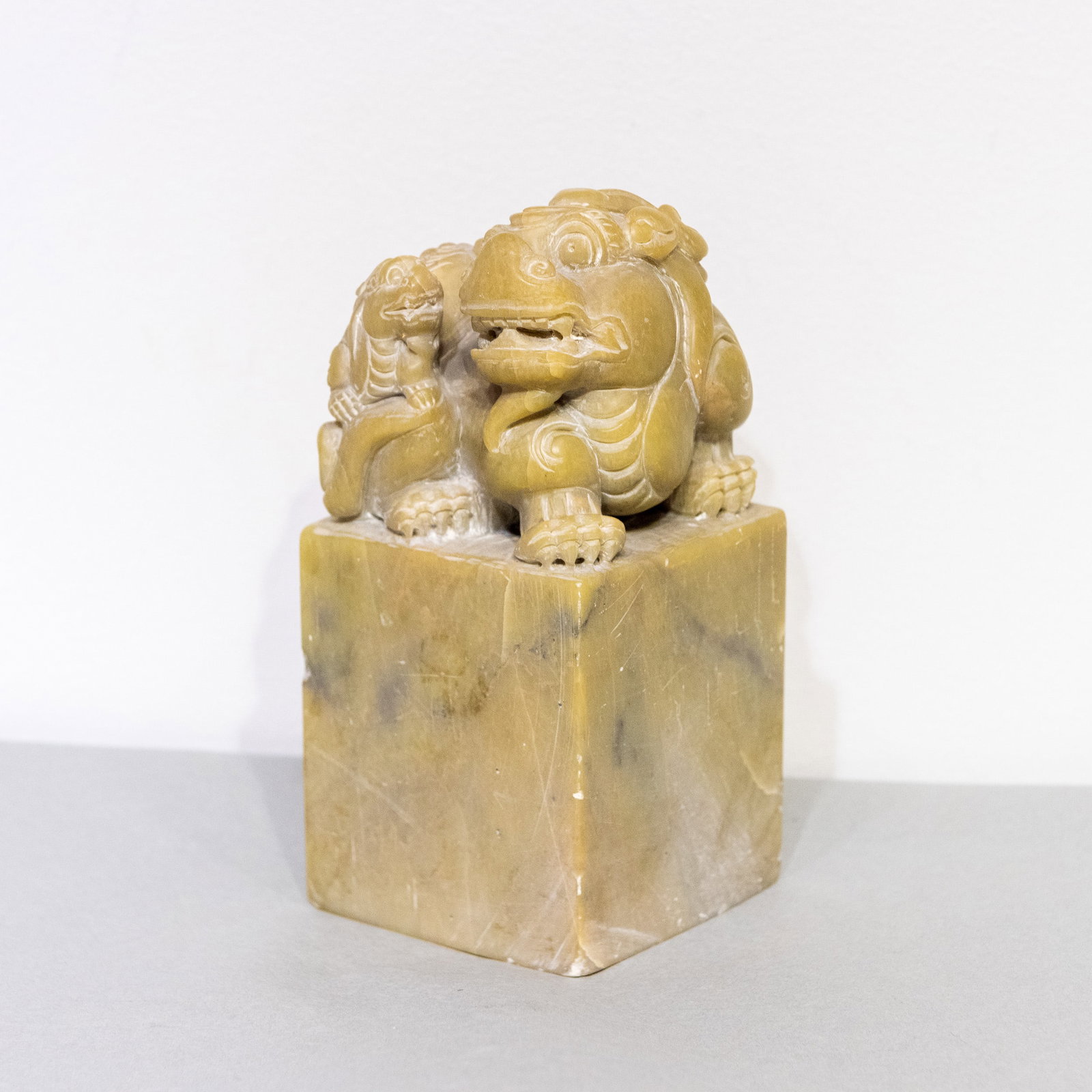 A CHINESE CARVED STONE STAMP: A Chinese carved stone stamp. 7.48"h x 3.46"w x 3.54"l (19 x 8.8 x 9 cm)