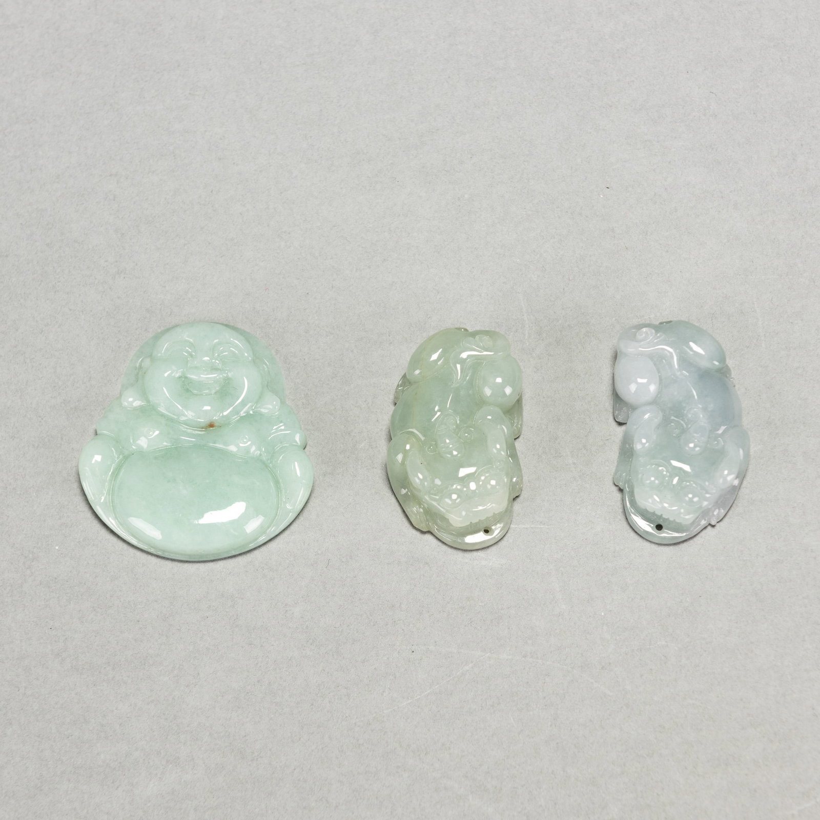 (LOT OF 3) A GROUP OF CHINESE JADEITE PENDANTS: (lot of 3) A group of Chinese jadeite pendants. 4 x 2.5 x 1 cm (x2); 4.6 x 4.2 x 0.7 cm