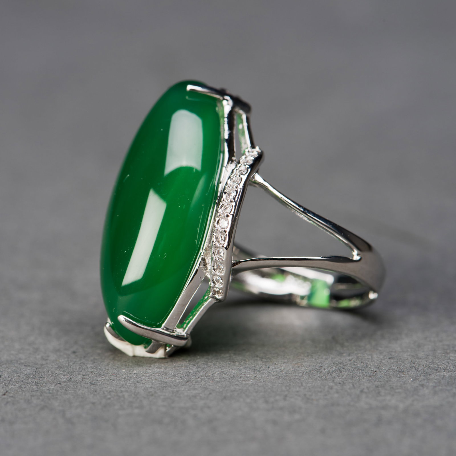 JADEITE AND DIAMOND RING: Chinese jadeite and diamond ring. 0.25"h x 0.5"w x 1"l (0.64 x 1.27 x 2.54 cm)