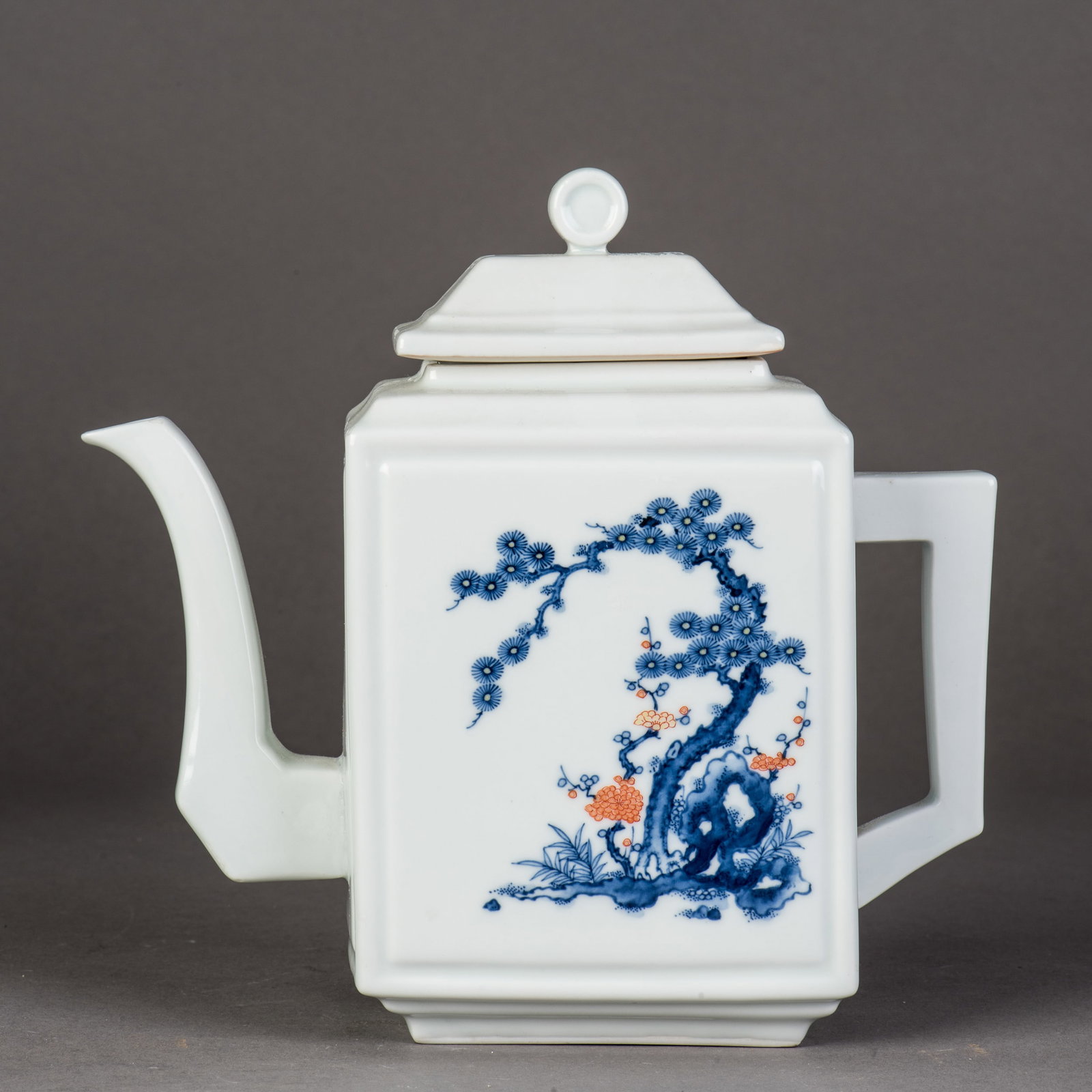 A CHINESE BLUE-AND-WHITE TEAPOT: A Chinese blue-and-white teapot of faceted form, decorated with blossoming tree branches and bearing a Meissen mark on the base. 7"h x 7.5"w x 3"l (17.78 x 19.05 x 7.62 cm) Condition: Small cracks to