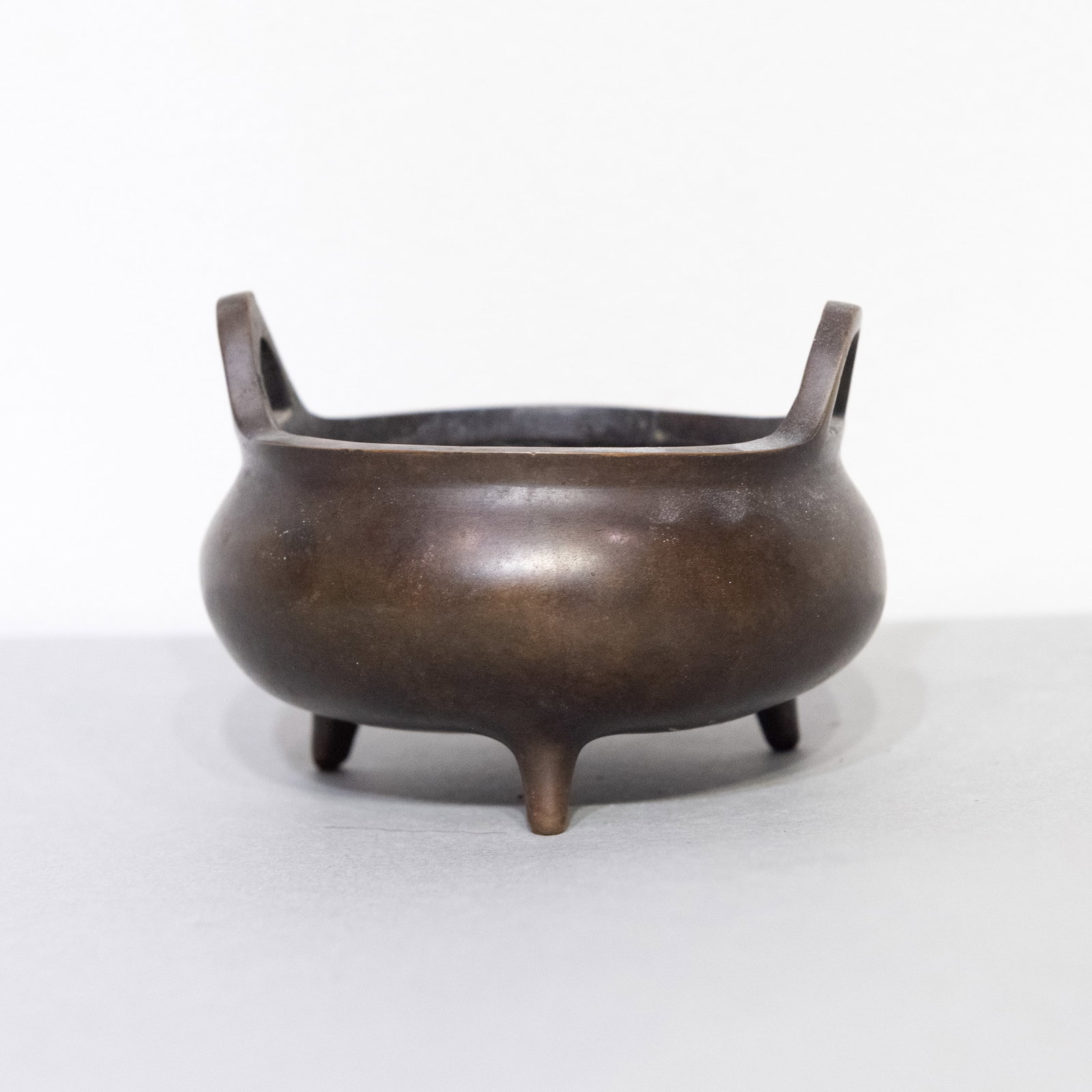 A CHINESE BRONZE TRIPOD CENSER: A Chinese bronze tripod censer. 2.95"h x 4.33"d (7.5 x 11 cm)