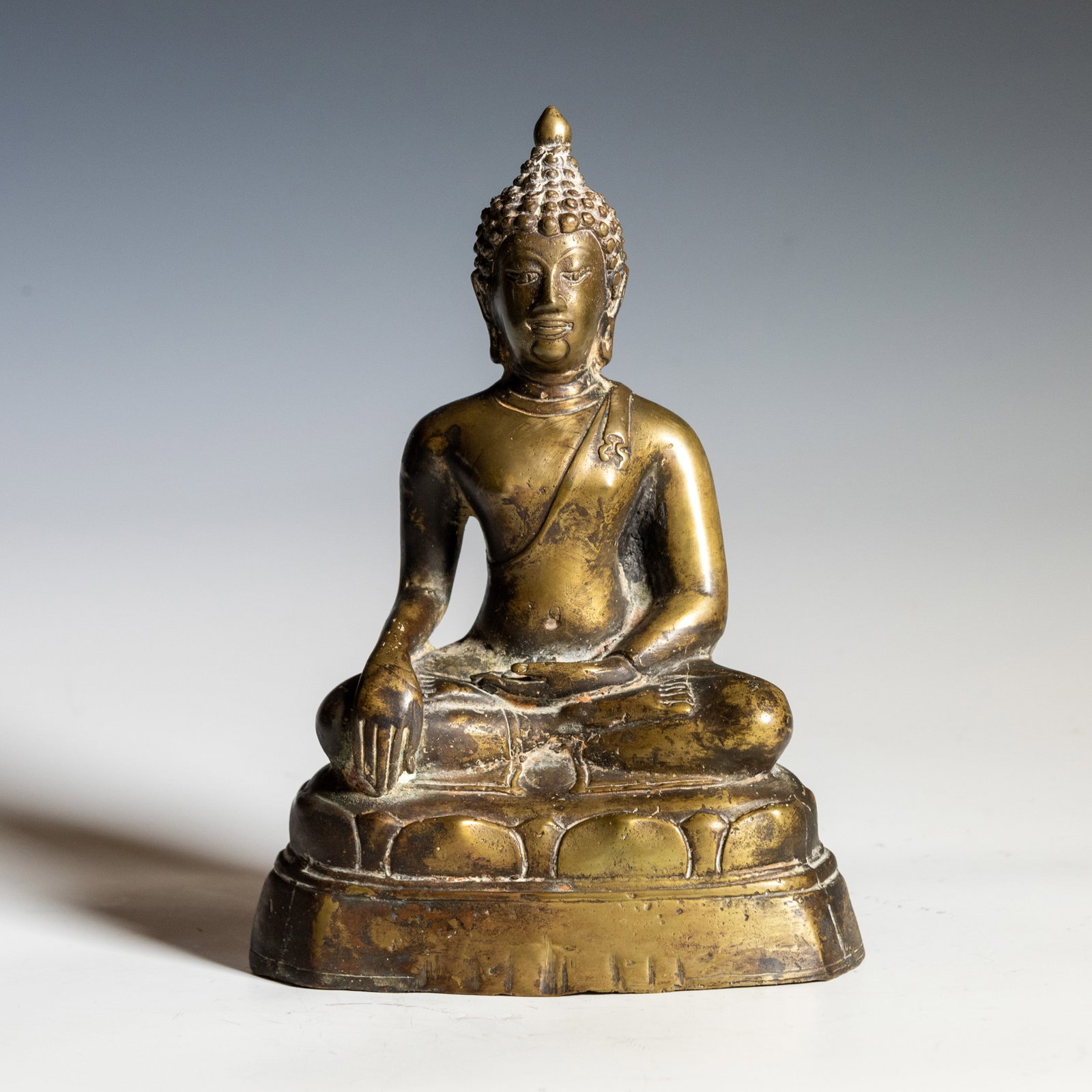 GILT-BRONZE FIGURE OF BUDDHA SHAKYAMUNI: Gilt-bronze figure of Buddha Shakyamuni. 8.46"h x 6.1"w x 3.35"l (21.5 x 15.5 x 8.5 cm)
