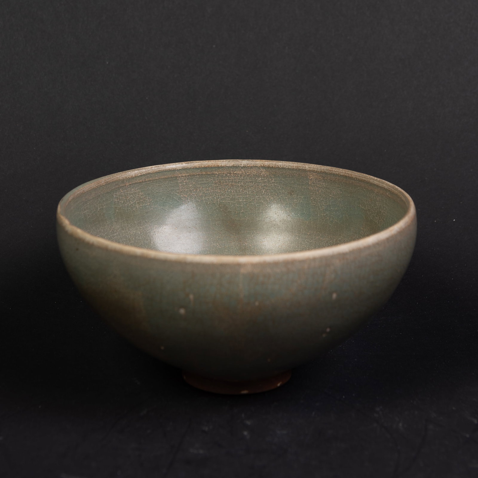 A CELADON PORCELAIN VASE: A celadon porcelain vase with rounded sides rising to a slightly inverted form. 3"h x 6"d