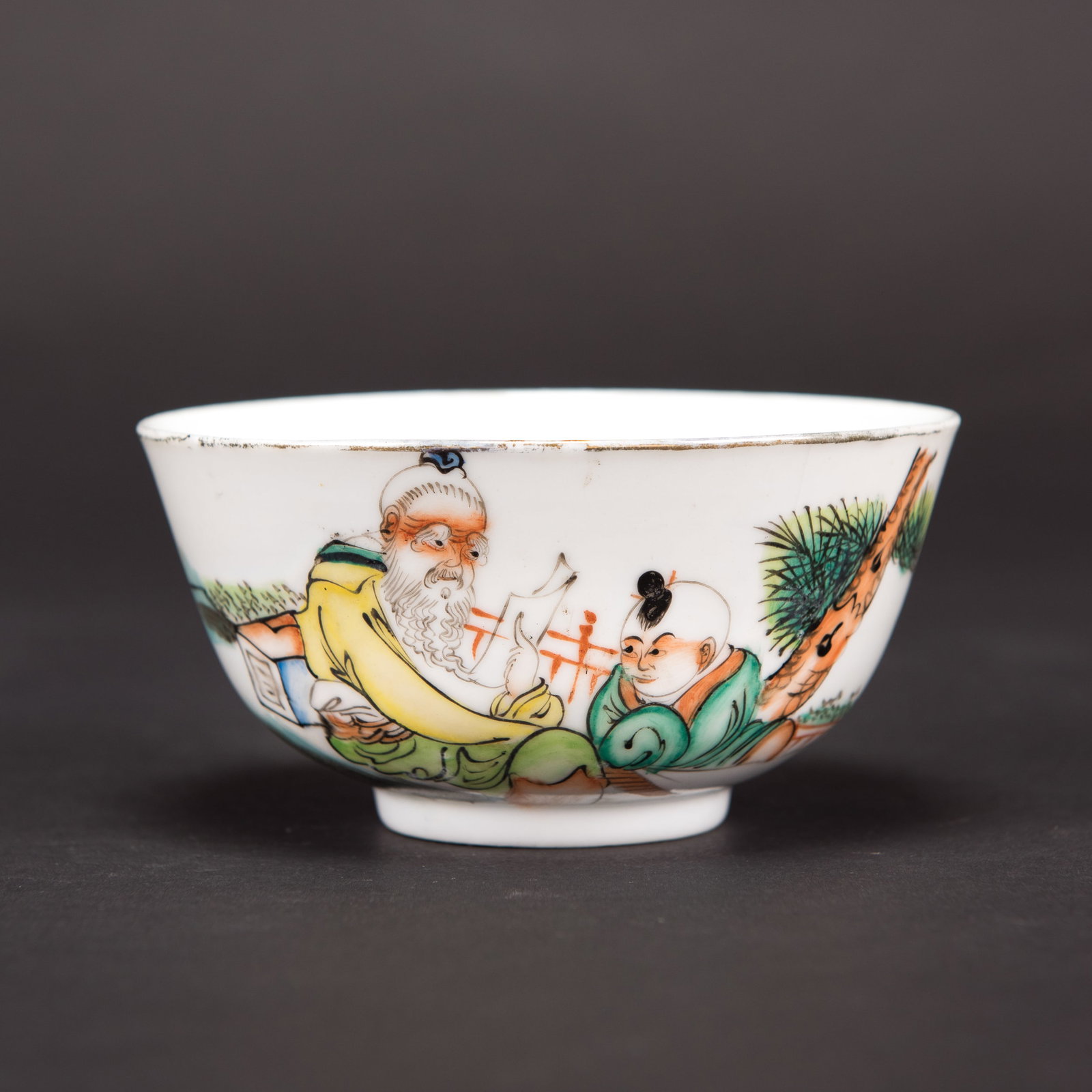 CHINESE FAMILLE-ROSE 'LONGEVITY GOD' PORCELAIN BOWL, REPUBLIC PERIOD: A Chinese famille-rose porcelain bowl decorated with a longevity god and a child, with calligraphy on the other side and a red six-character mark on the base, Republic period. 2.36"h x 4.13"w (6 x
