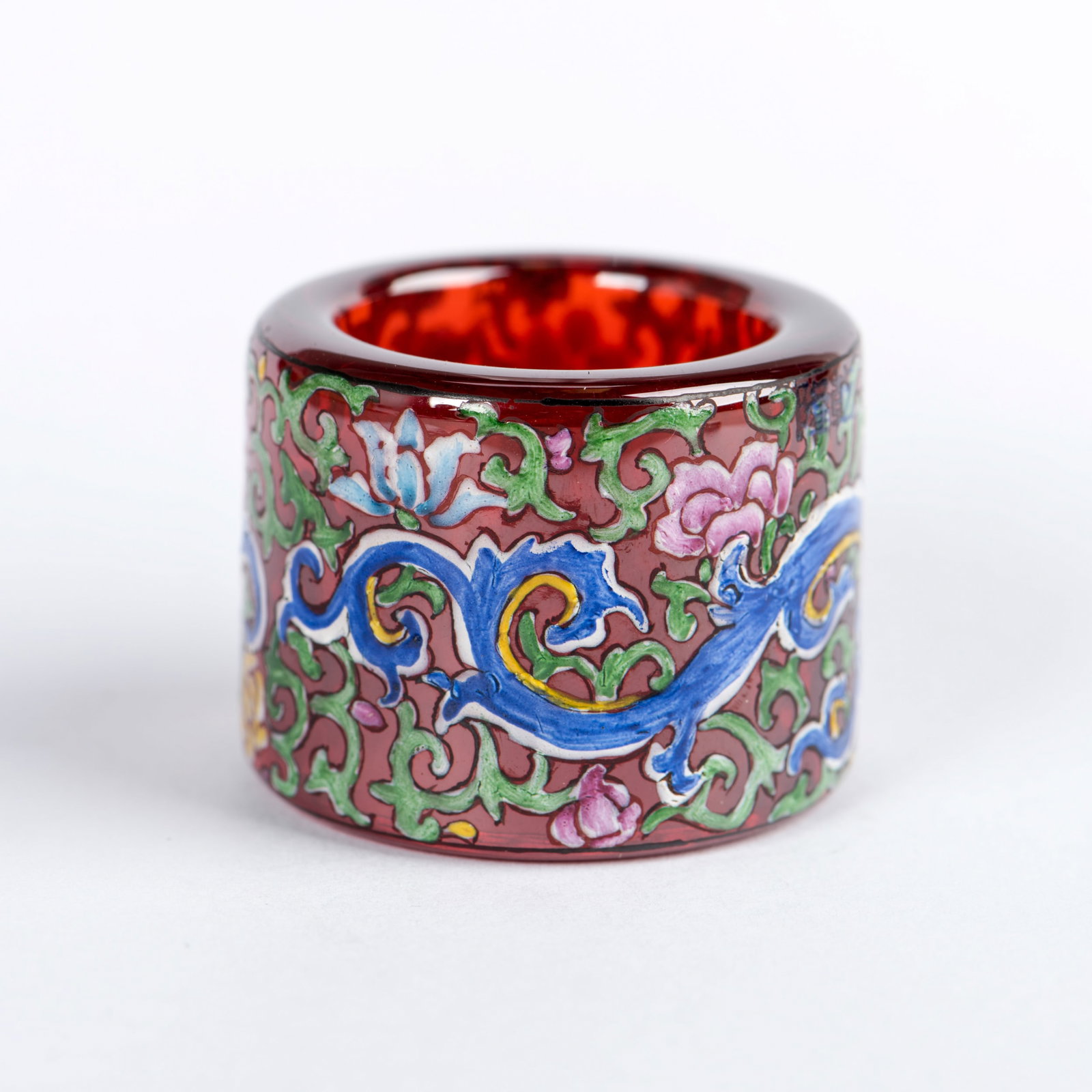 A PAINTED GLASS THUMB RING: A painted glass thumb ring. 1"h x 1.5"d (2.54 x 3.81 cm)