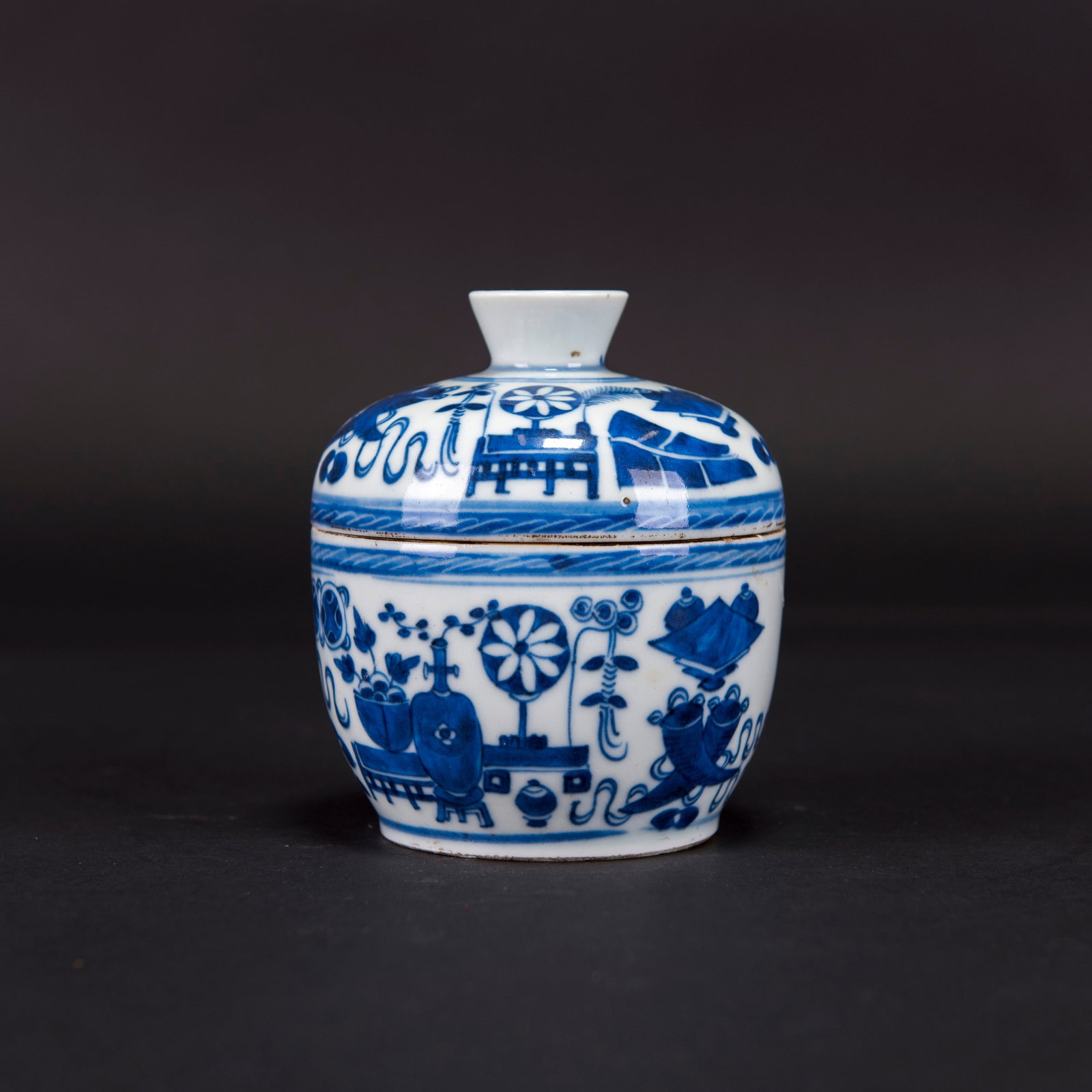 CHINESE BLUE-AND-WHITE BOWL AND COVER: Chinese blue-and-white bowl and cover with deep rounded sides, painted with antiques and precious objects; the cover is similarly decorated. 4.72"h x 4.33"w (12 x 11 cm) Provenance: Estate sale from