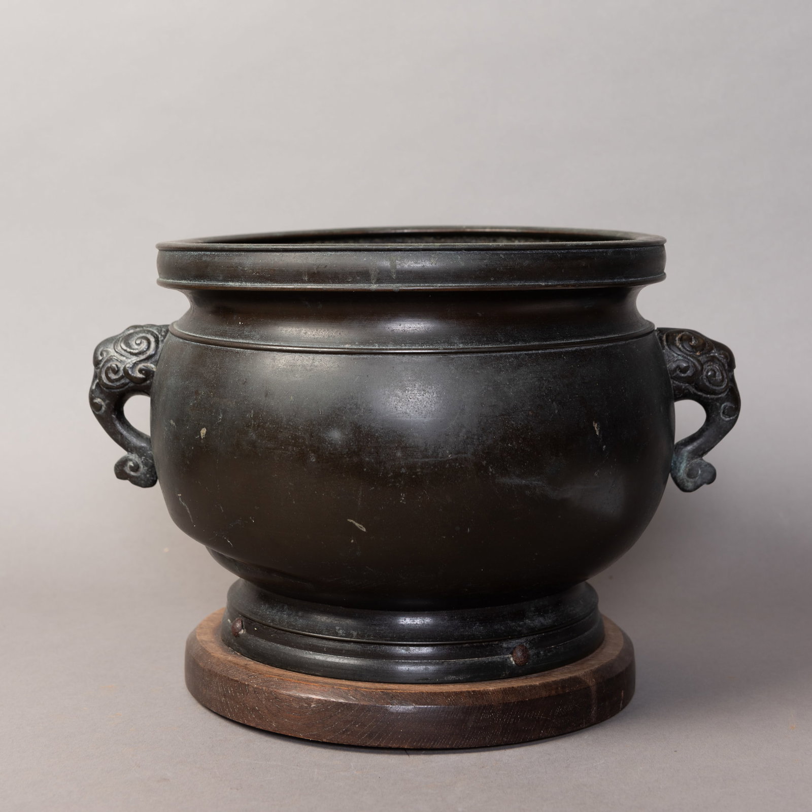 A BRONZE CENSER WITH A WOOD BASE: A bronze censer with a wood base. 7.5"h x 12.5"w (19.05 x 31.75 cm)