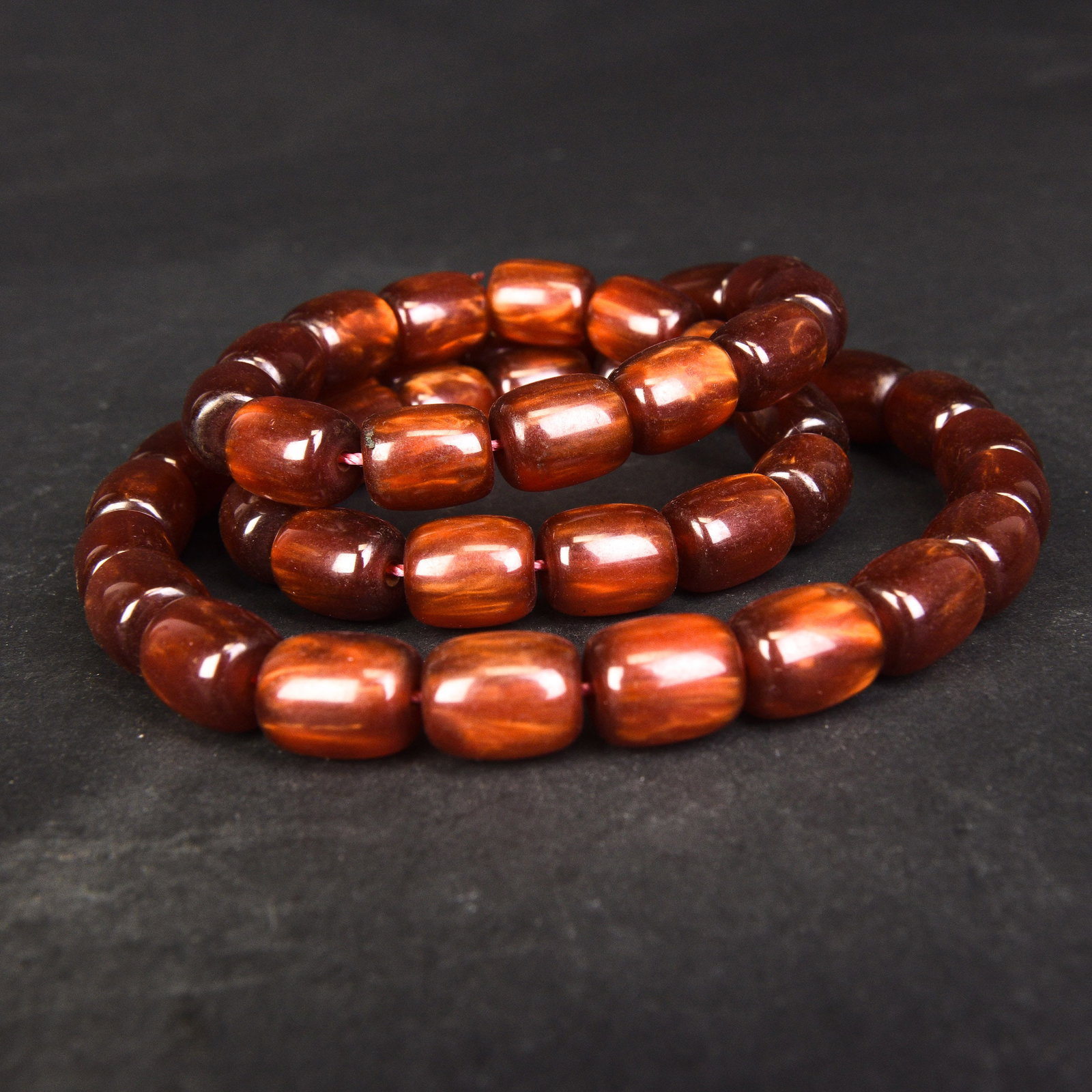 A STRING OF AMBER BEADS: A string of amber beads. L38 cm (x2)