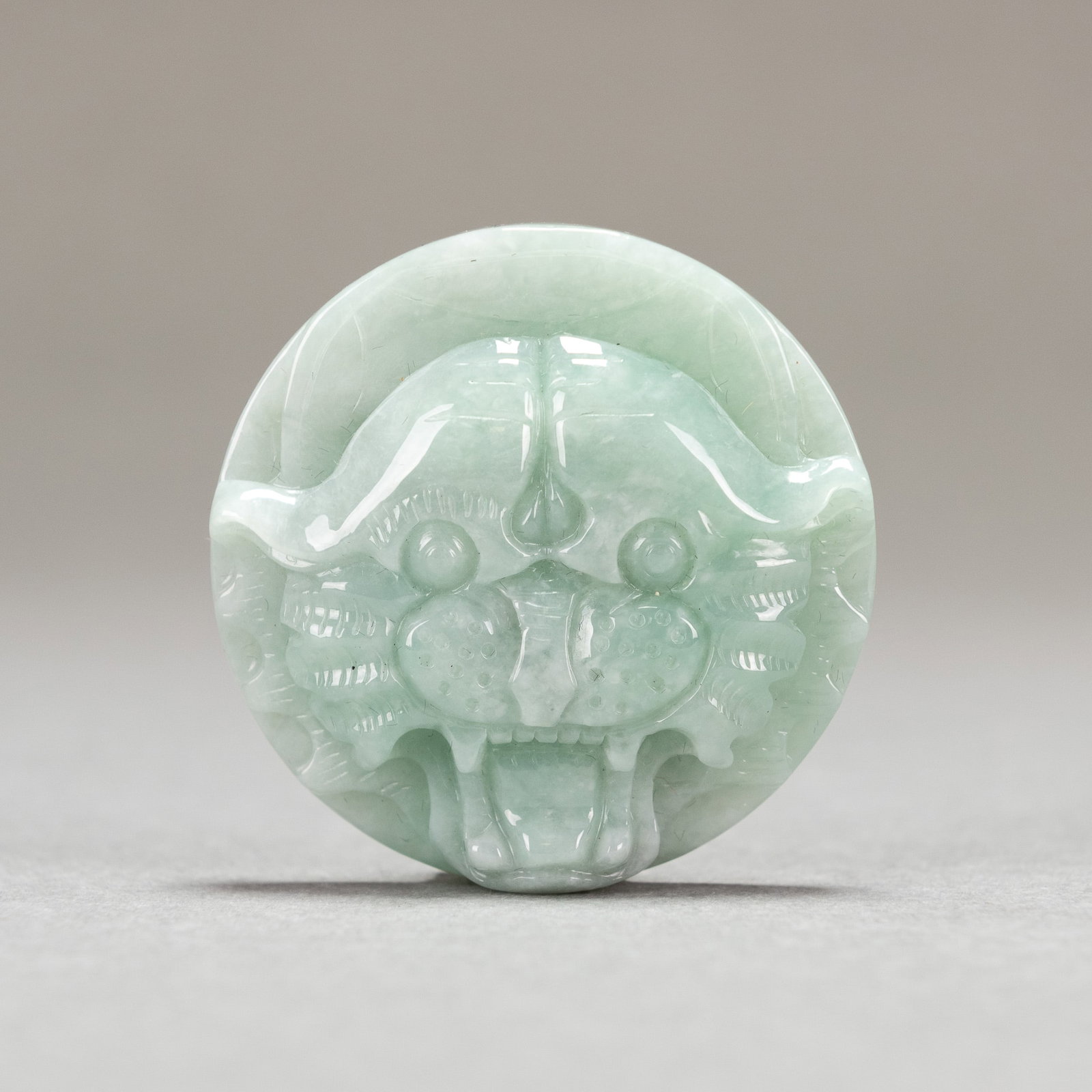 A CHINESE JADEITE ORNAMENT: A Chinese jadeite ornament. Diameter: 5 cm; Thickness: 2 cm