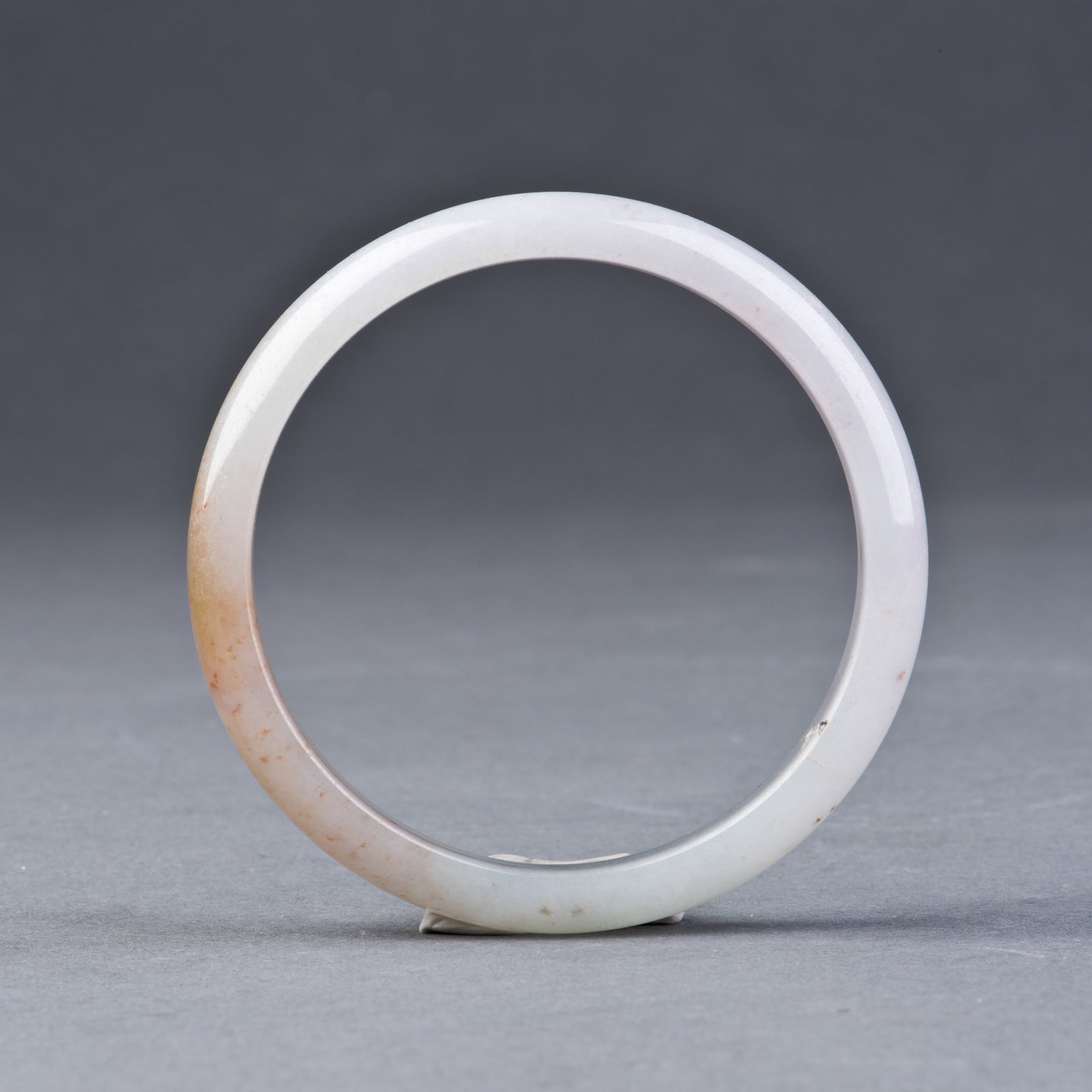 JADEITE BANGLES: Jadeite bangles of translucent icy color with caramel-colored suffusions. D5.7 cm