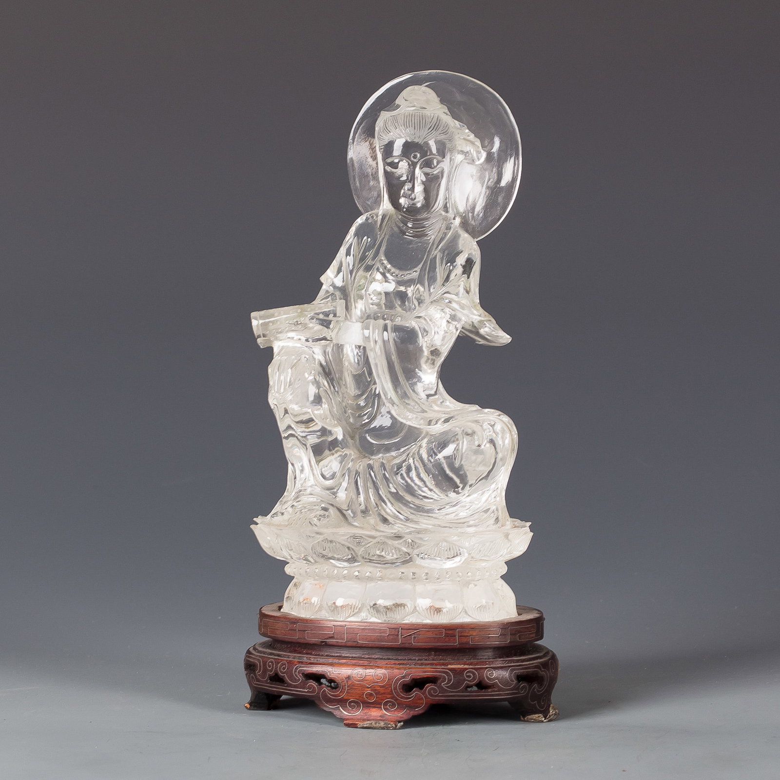 CHINESE ROCK CRYSTAL GUANYIN: Chinese rock crystal Guanyin with a serene expression, seated on a lotus pedestal stand. 7.87"h x 3.94"w (20 x 10 cm)