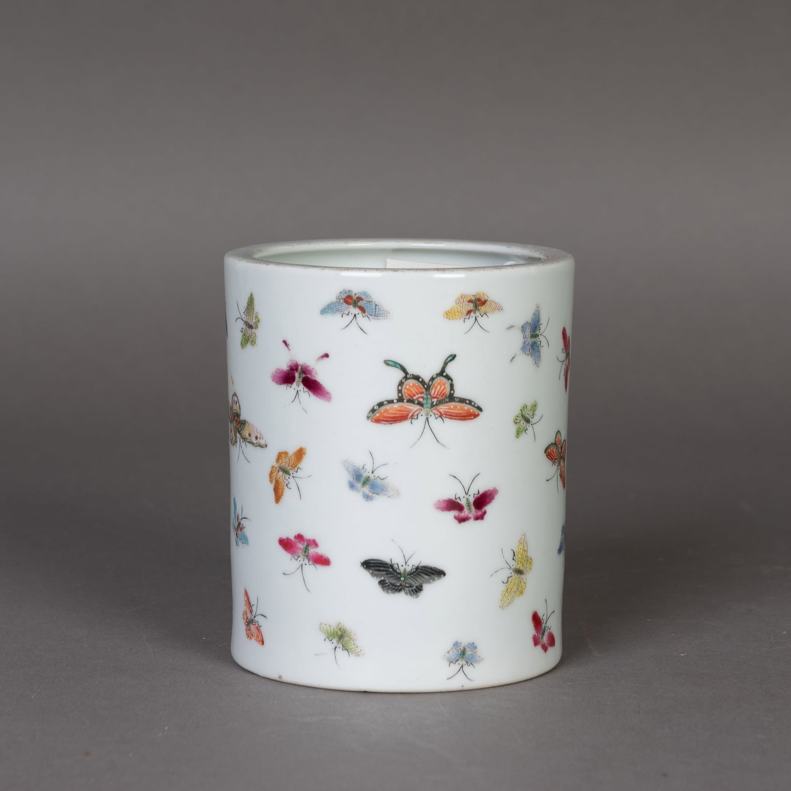 A FAMILLE-ROSE 'BUTTERFLY' PORCELAIN BRUSH POT: A famille-rose 'butterfly' porcelain brush pot. H10 x 9 cm