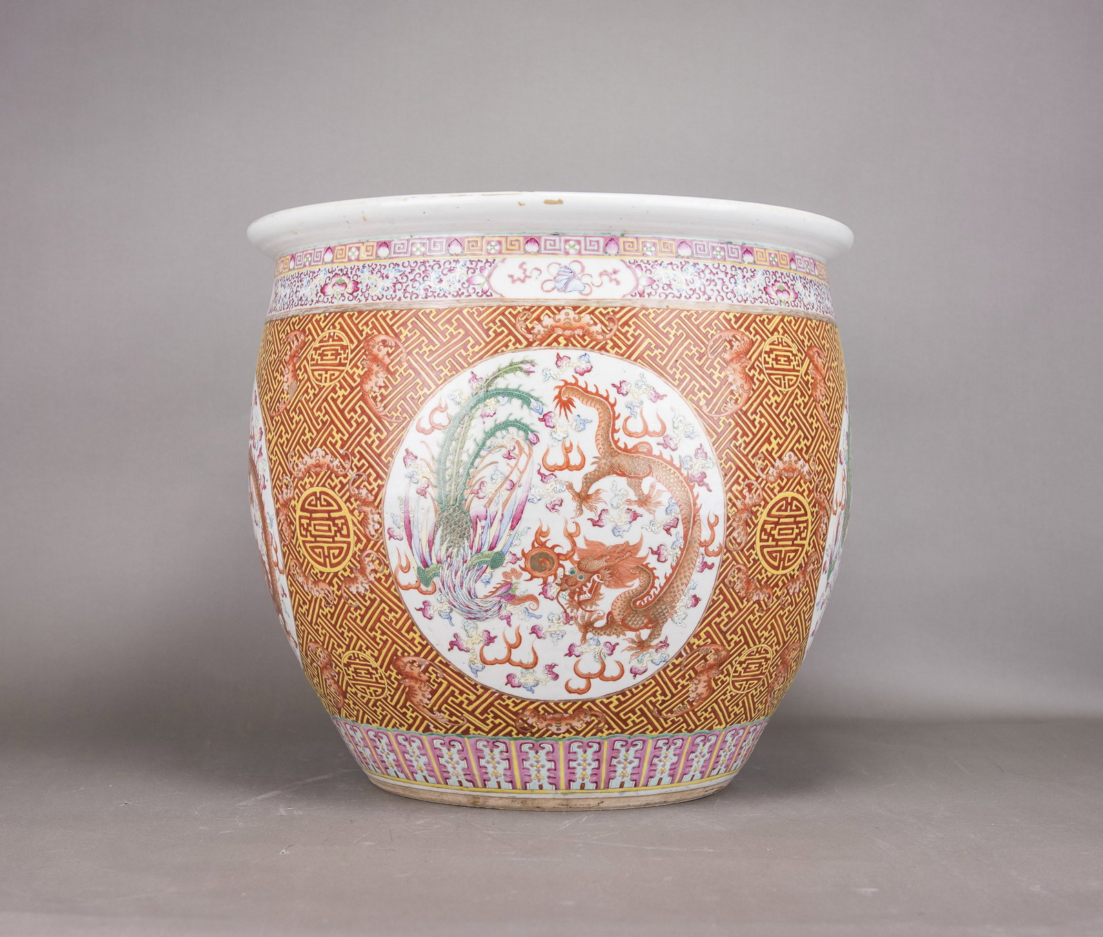 A FAMILLE-ROSE 'DRAGON AND PHOENIX' JAR, 19TH CENTURY: A famille-rose 'dragon and phoenix' jar, 19th century. The exterior is decorated with roundels enclosing a dragon and phoenix chasing a flaming pearl, with geometric patterns and bats. 18.9"h x