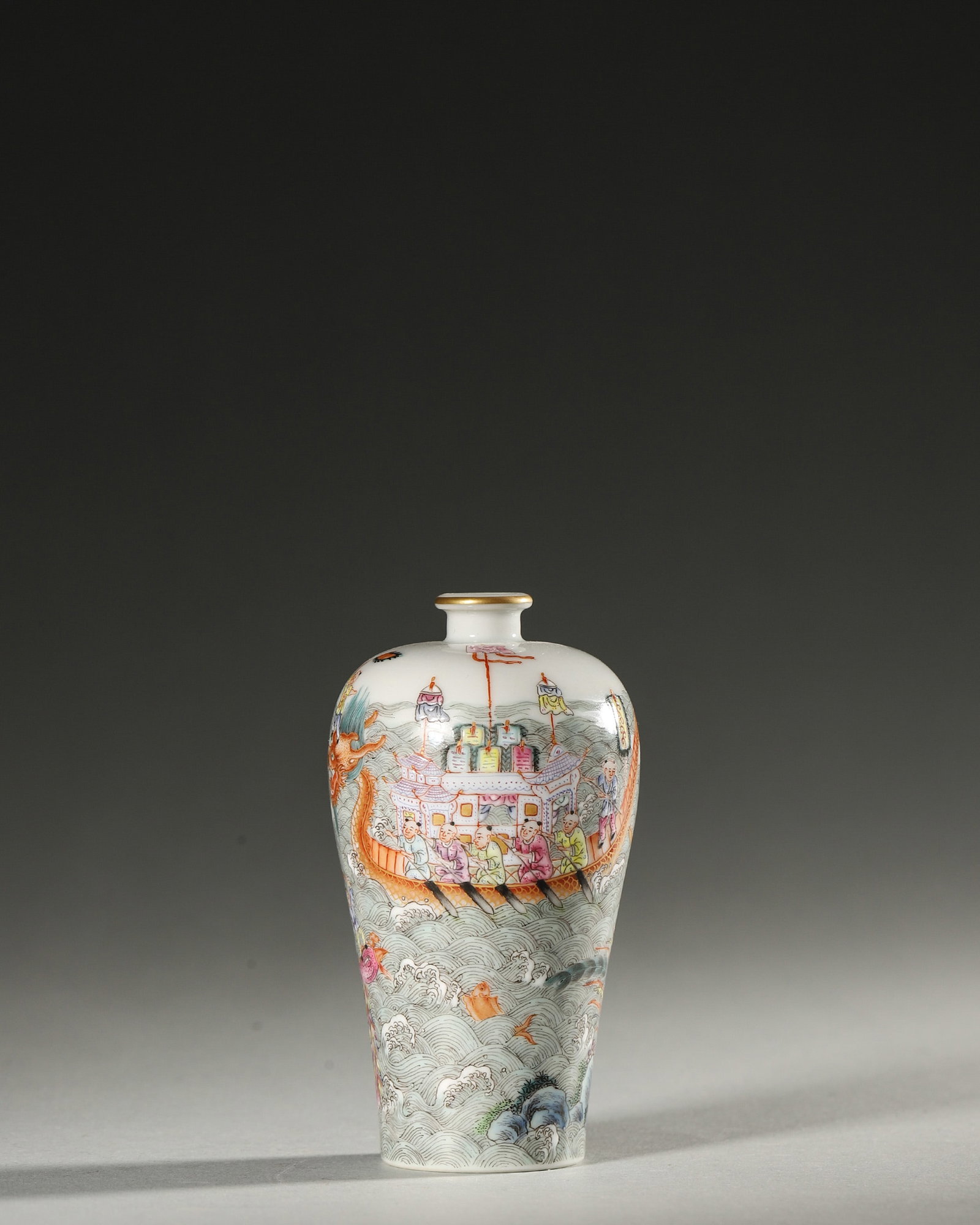 A FAMILLE-ROSE 'DRAGON BOAT' PORCELAIN SNUFF BOTTLE: A famille-rose porcelain snuff bottle decorated with a dragon-boat scene. Diam. 5.3 cm; Ht. 9 cm.