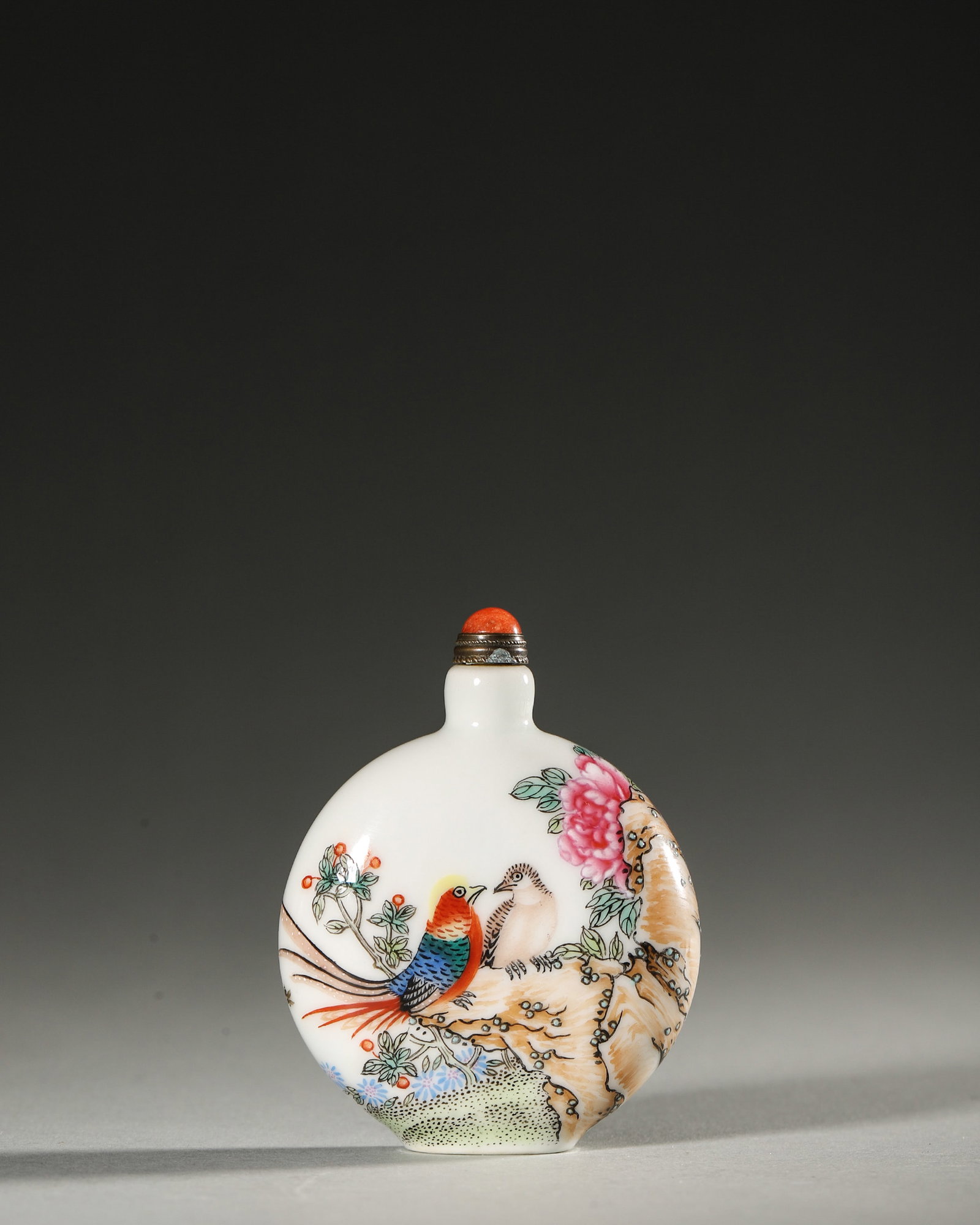 AN ENAMEL-DECORATED 'BIRD AND FLOWER' PORCELAIN SNUFF BOTTLE: An enamel-decorated porcelain snuff bottle with bird-and-flower motifs. Diam. 5.2 cm; Ht. 6.8 cm.