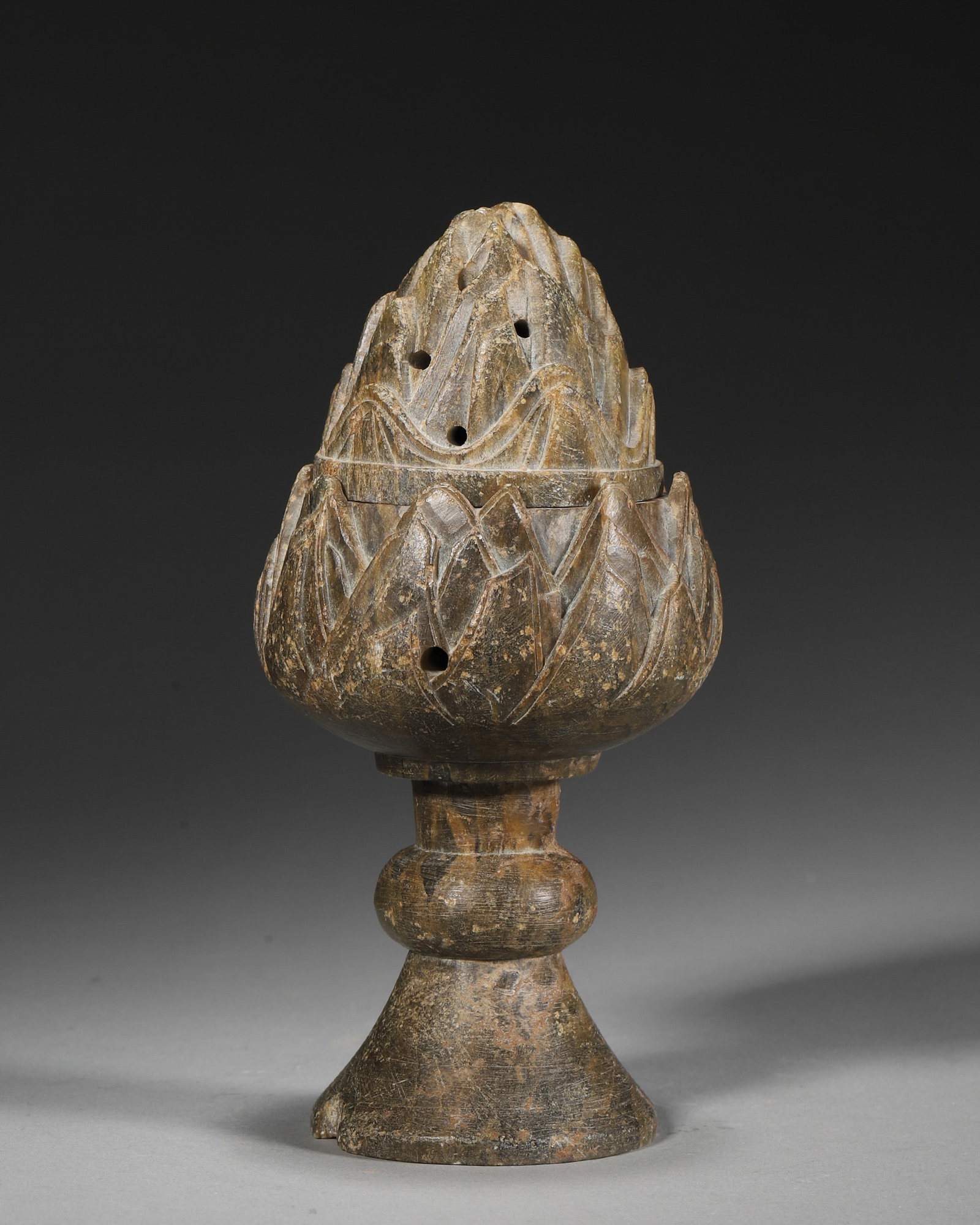 A CARVED INCENSE BURNER: A carved incense burner with a pierced mountain-form cover on a stemmed base. W. 7 cm; Ht. 15 cm; Wt. 431 g.