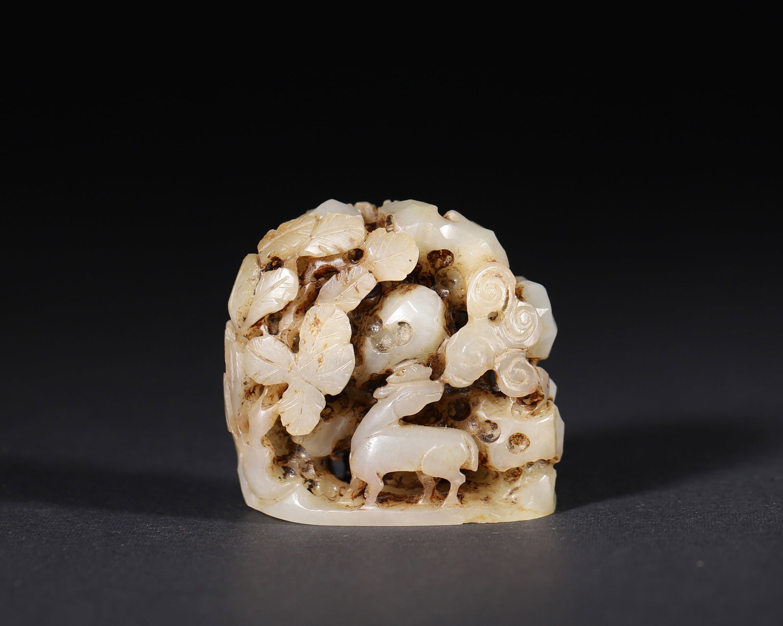 A WHITE JADE OPENWORK 'DEER' CENSER FINIAL: A white jade censer finial carved in openwork with deer and layered motifs. L. 4 cm; W. 2.4 cm; Ht. 4 cm; Wt. 52 g.