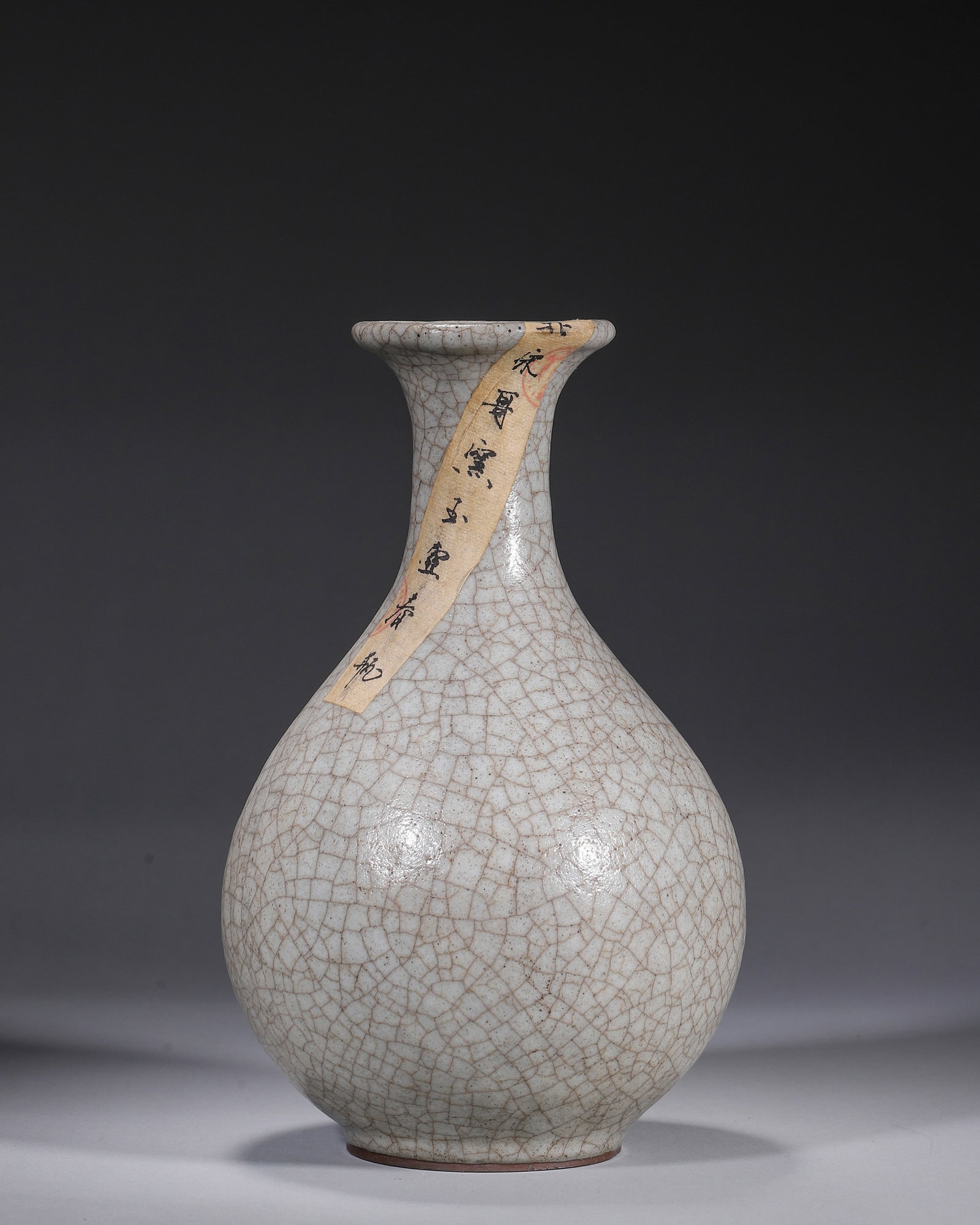 A GE-TYPE CRACKLE-GLAZED PEAR-SHAPED VASE: A pear-shaped vase with a flared rim and tapered neck, covered in a creamy Ge-type crackle glaze. Diam. 14 cm; Ht. 23 cm. Note: With labels.