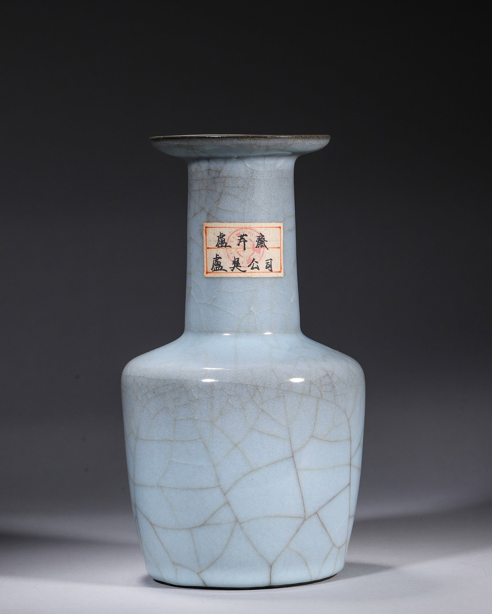 A GUAN-TYPE SKY-BLUE-GLAZED MALLET-FORM VASE: A mallet-form vase with a flared rim and straight neck, covered in a sky-blue Guan-type crackle glaze. Diam. 13 cm; Ht. 23 cm. Note: With a label and collector mark.