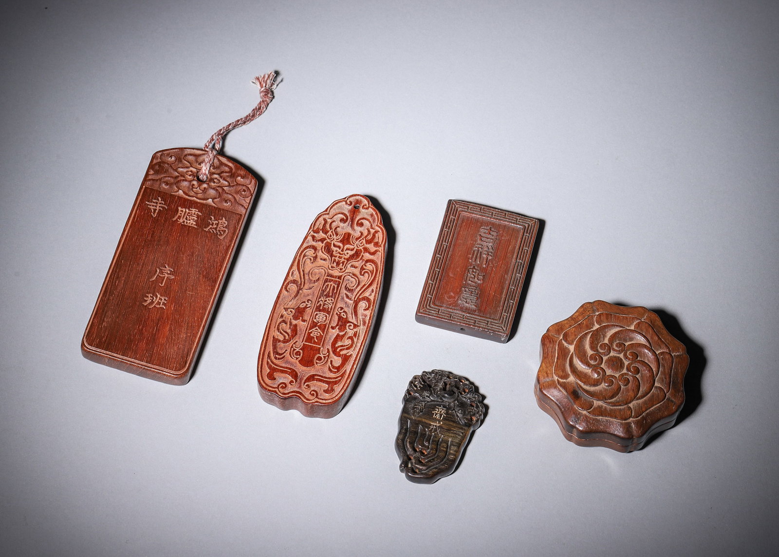 A SET OF FIVE CARVED WOOD PLAQUES, TALLIES AND BOX: A set of five carved wood objects comprising a rectangular plaque inscribed for Honglu Temple, a carved tally inscribed 'General's Tally', a small square plaque inscribed 'Ji Xing Shou Hei', an ebony 