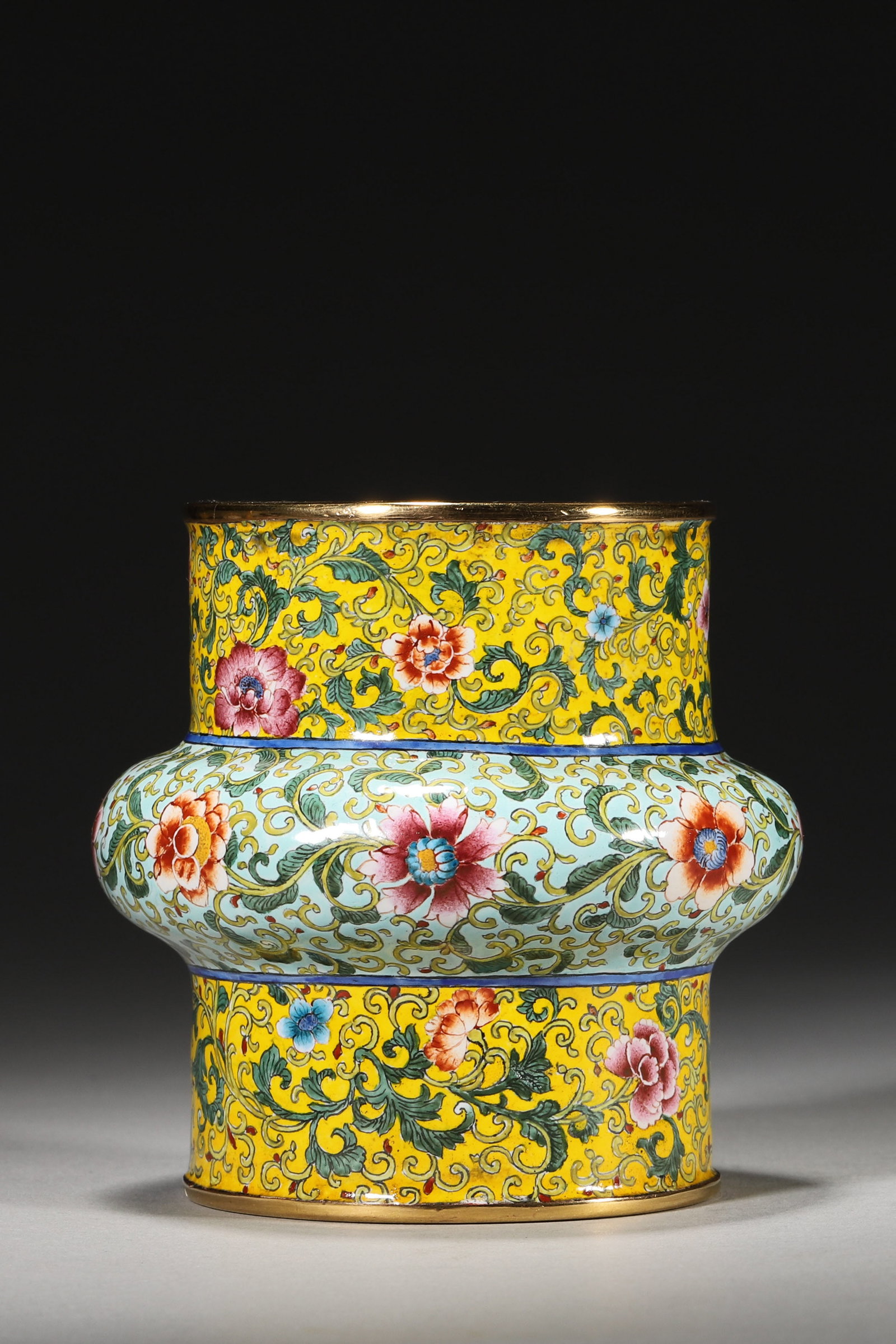 A COPPER-BODY PAINTED-ENAMEL WASTE BOWL WITH FLORAL SCROLLS: A copper-body painted-enamel waste bowl decorated with floral scrolls on multicolored grounds, with gilt rims. The base bears a Qianlong mark. Diam. 8 cm; Ht. 8 cm; Wt. 362 g.
