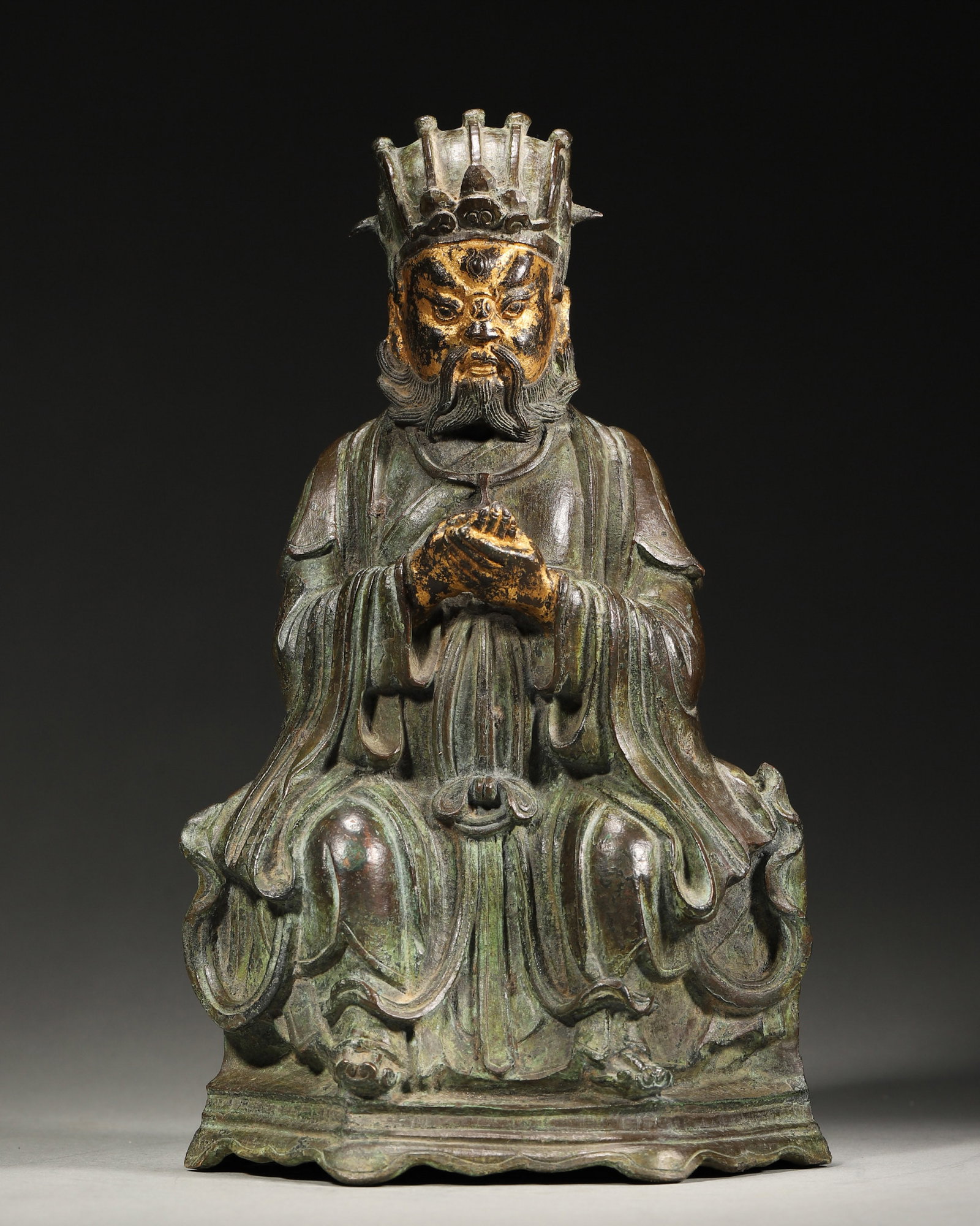 A GILT-BRONZE TAOIST FIGURE: A gilt-bronze Taoist figure seated on a raised base. L. 15 cm; Ht. 28 cm; Wt. 3,068 g.
