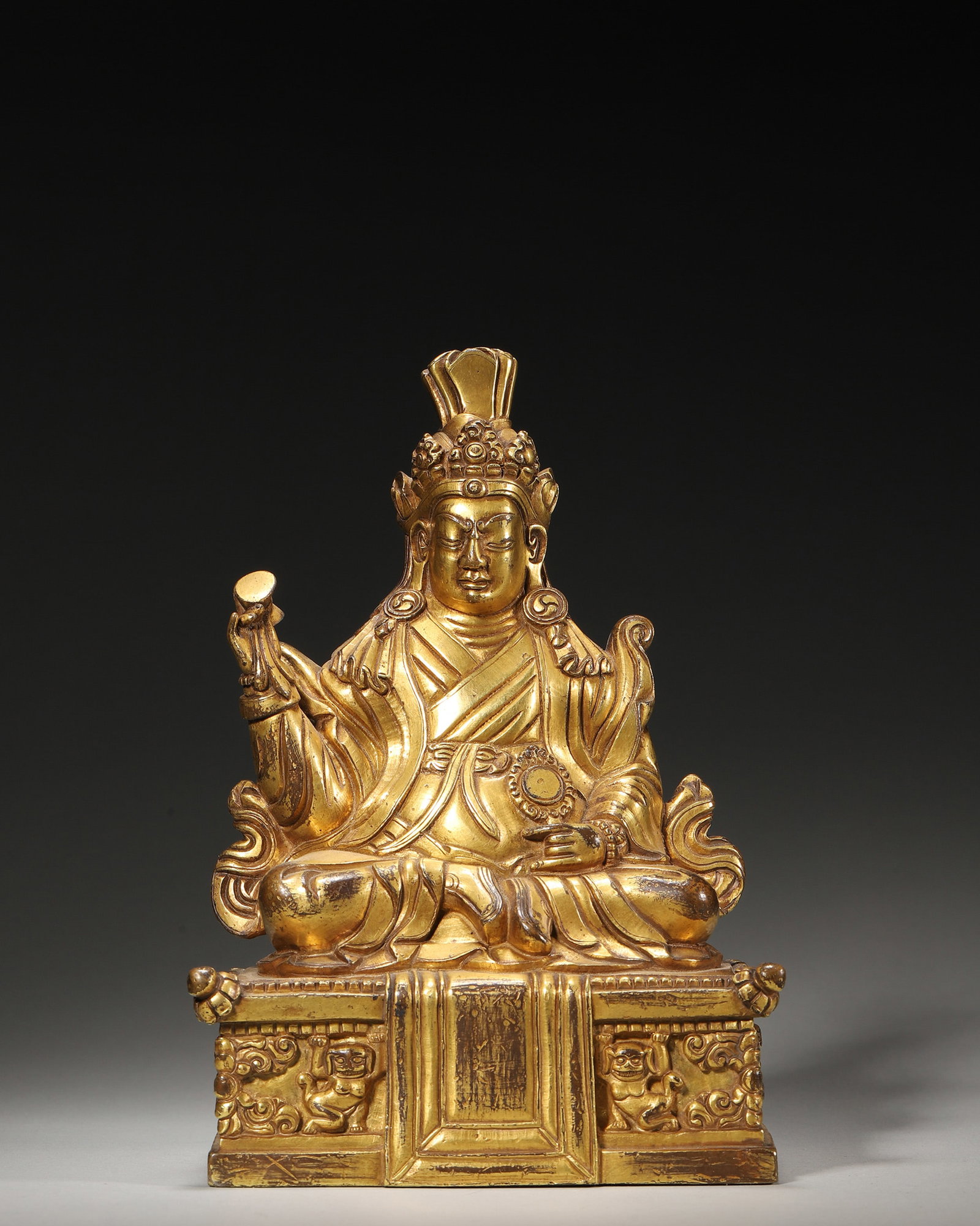 A GILT-BRONZE BUDDHA FIGURE: A gilt-bronze seated Buddha figure. W. 11 cm; Ht. 16 cm; Wt. 1,105 g.