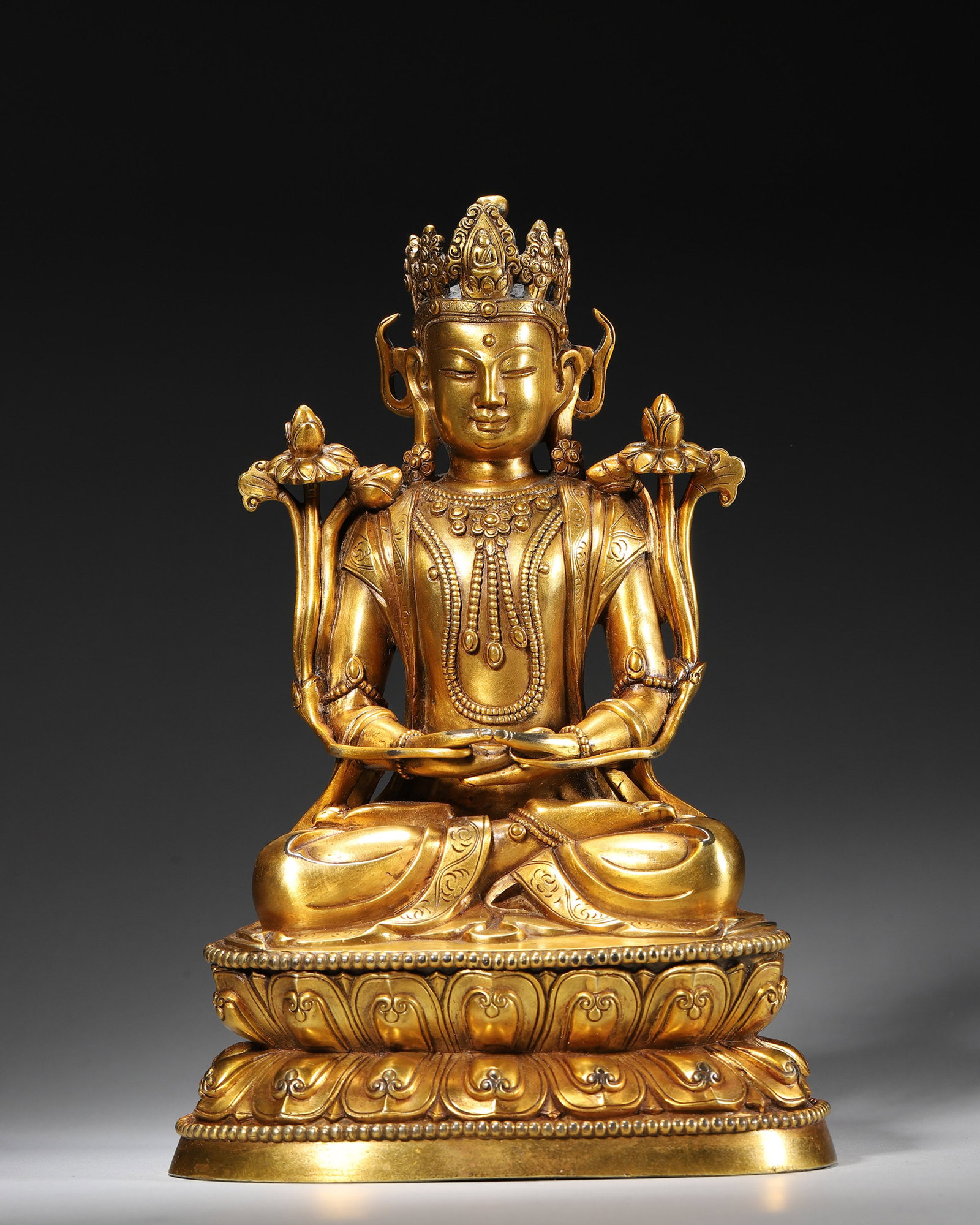 A GILT-BRONZE SEATED FIGURE OF GUANYIN: A gilt-bronze seated figure of Guanyin. W. 14 cm; Ht. 23 cm; Wt. 1,888 g.