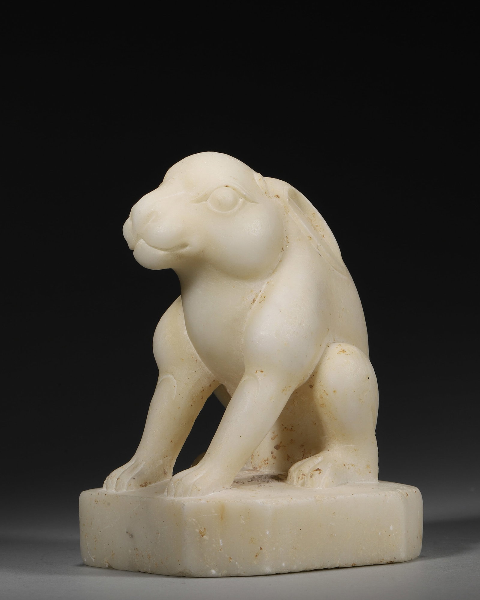 A WHITE JADE RABBIT-FORM PAPERWEIGHT: A white jade paperweight carved in the form of a rabbit. L. 9 cm; W. 7.5 cm; Ht. 12 cm; Wt. 810 g.