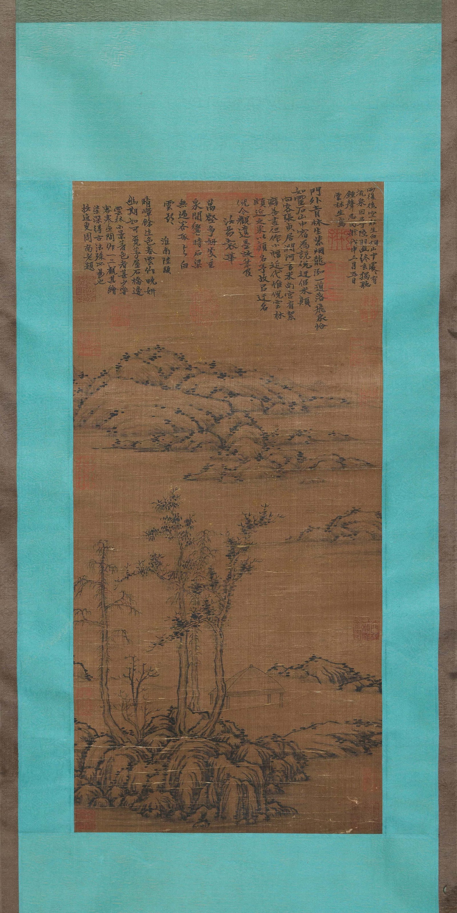 NI ZAN, ATTRIBUTED TO, THATCHED PAVILION BY STREAM AND HILLS, HANGING SCROLL: Attributed to Ni Zan. Ink on silk, hanging scroll, depicting a sparse landscape with rocks, trees, a thatched pavilion, distant hills and open water. The work bears a lengthy inscription and multiple