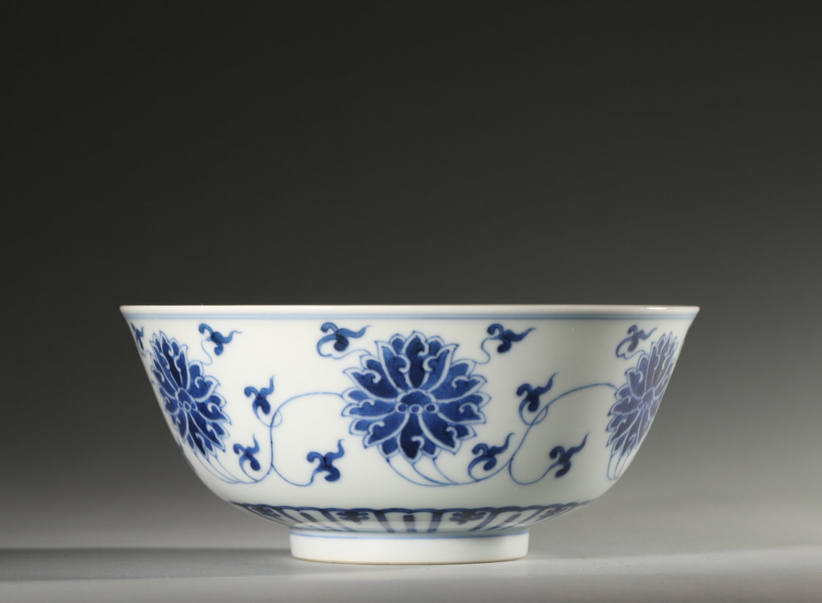 A BLUE-AND-WHITE INTERLOCKING-LOTUS PORCELAIN BOWL: A blue-and-white porcelain bowl decorated with interlocking lotus scrolls. Diam. 17 cm; Ht. 7.5 cm.