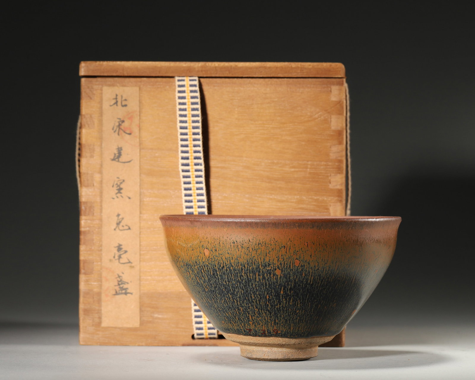 A 'HARE'S-FUR' JIAN-STYLE TEA BOWL: A Jian-style tea bowl covered in a lustrous black glaze with fine golden hare's-fur streaks. The base bears a mark described in the source as 'Gong Yu'. Diam. 12.5 cm; Ht. 7.5 cm. Note: By repute, ass