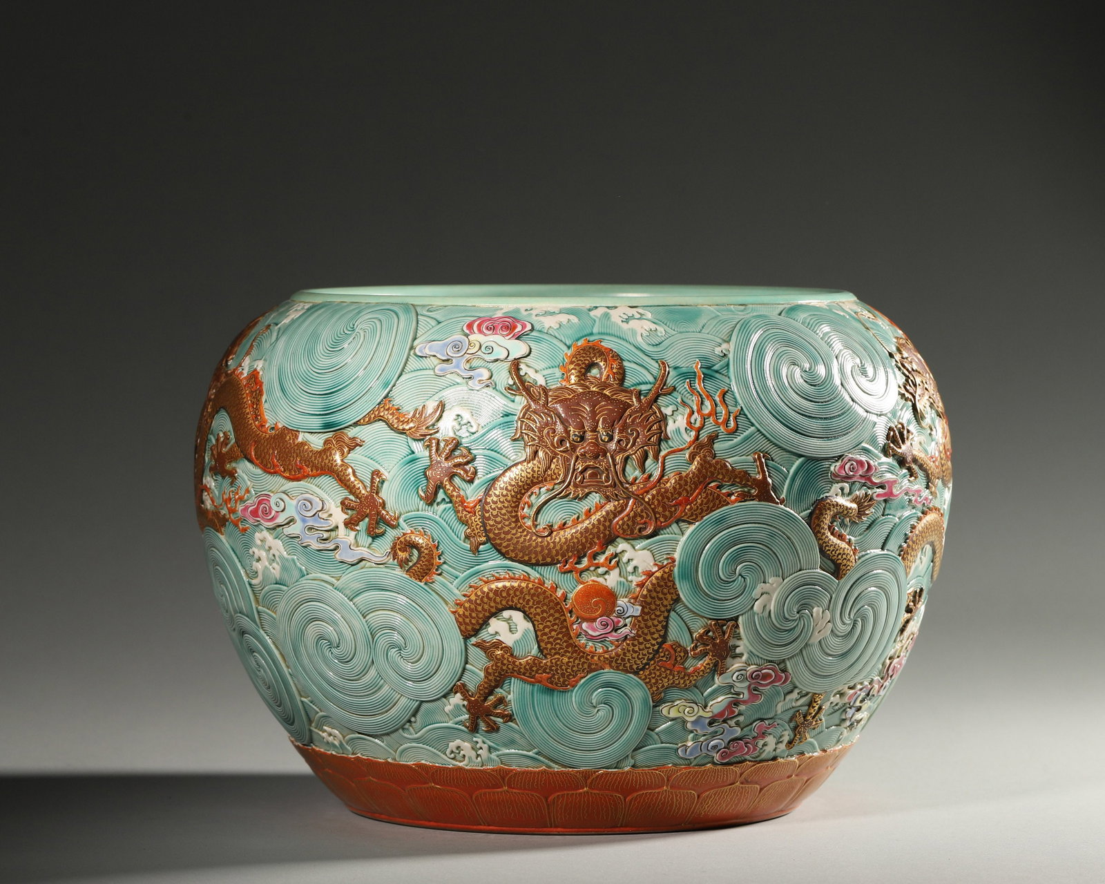 A RELIEF-DECORATED 'DRAGON AND WAVE' PORCELAIN JAR: A porcelain jar decorated in relief with a dragon amid waves. Diam. 24 cm; Ht. 26 cm.