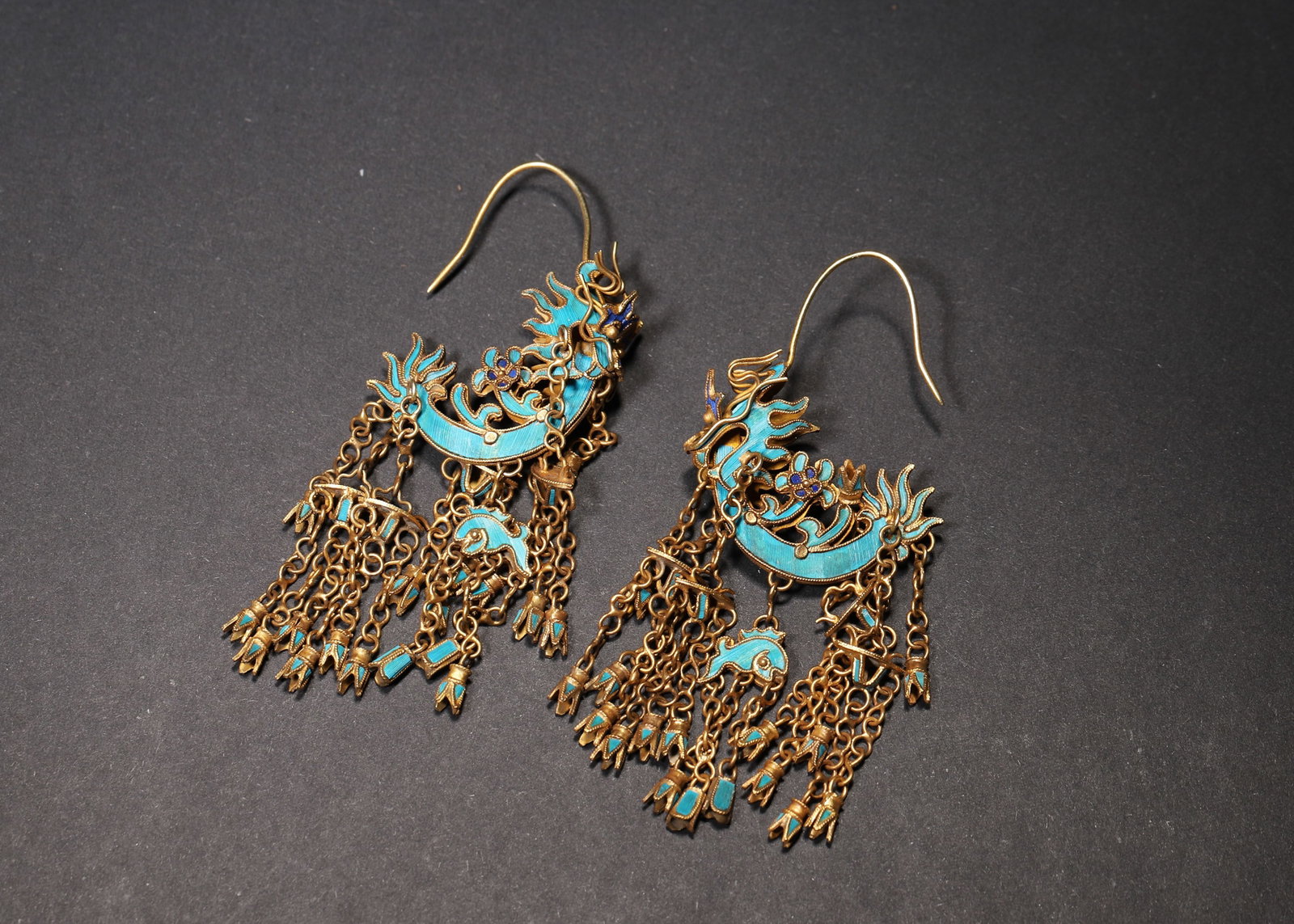 A PAIR OF GILT-SILVER, KINGFISHER-FEATHER AND ENAMEL PHOENIX EARRINGS: A pair of gilt-silver earrings with kingfisher-feather and enamel phoenix decoration and tassel pendants. L. 7 cm; W. 3 cm; Total Wt. 20 g.