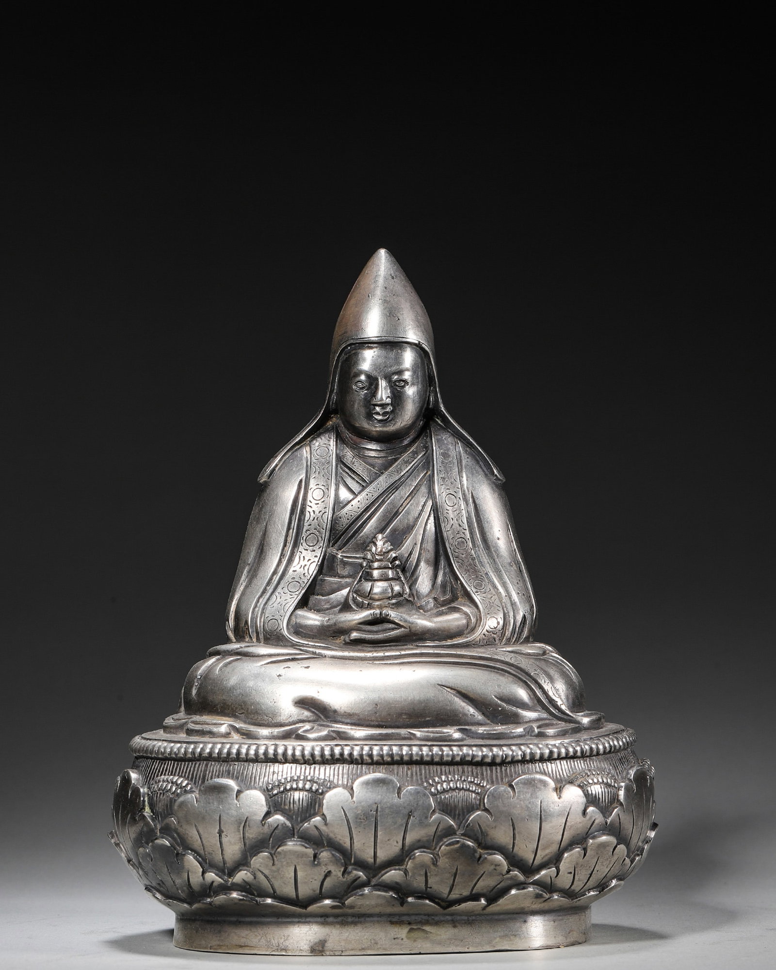 A SILVER-PLATED COPPER FIGURE OF TSONGKHAPA: A silver-plated copper figure of Tsongkhapa. W. 13 cm; Ht. 17 cm; Wt. 1,478 g.