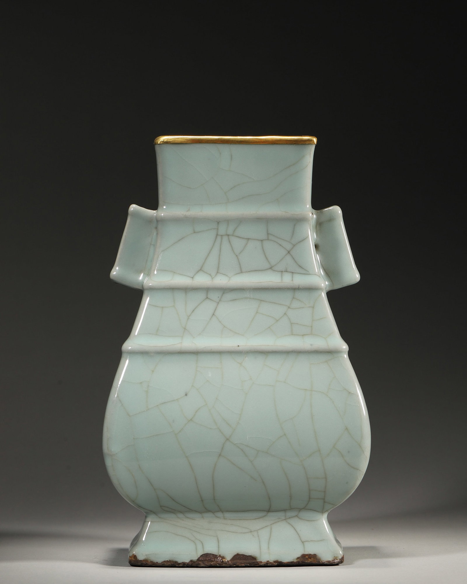 A GUAN-TYPE CELADON VASE WITH LOOP HANDLES: A celadon-glazed porcelain vase with loop handles, crackle glaze and a gilt-metal-mounted rim. The base bears a three-character mark reading 'Yujinyuan'. L. 15 cm; W. 12 cm; Ht. 24 cm.