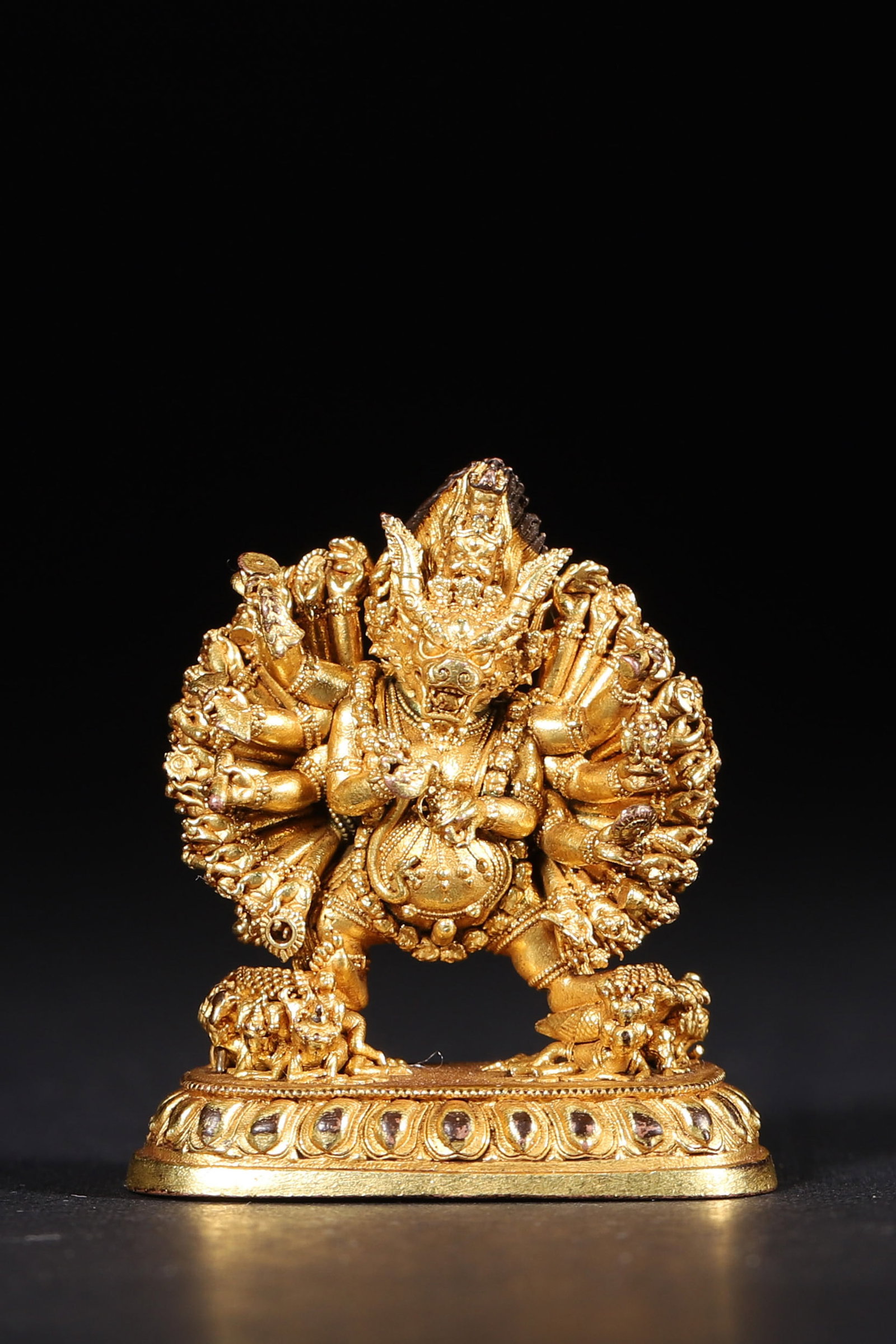 A GILT-BRONZE FIGURE OF YAMANTAKA: A gilt-bronze figure of Yamantaka holding ritual implements and trampling figures, with rich gilding. Dimensions: 3.5 x 1.8 x 3.8 cm; Wt. 26 g.