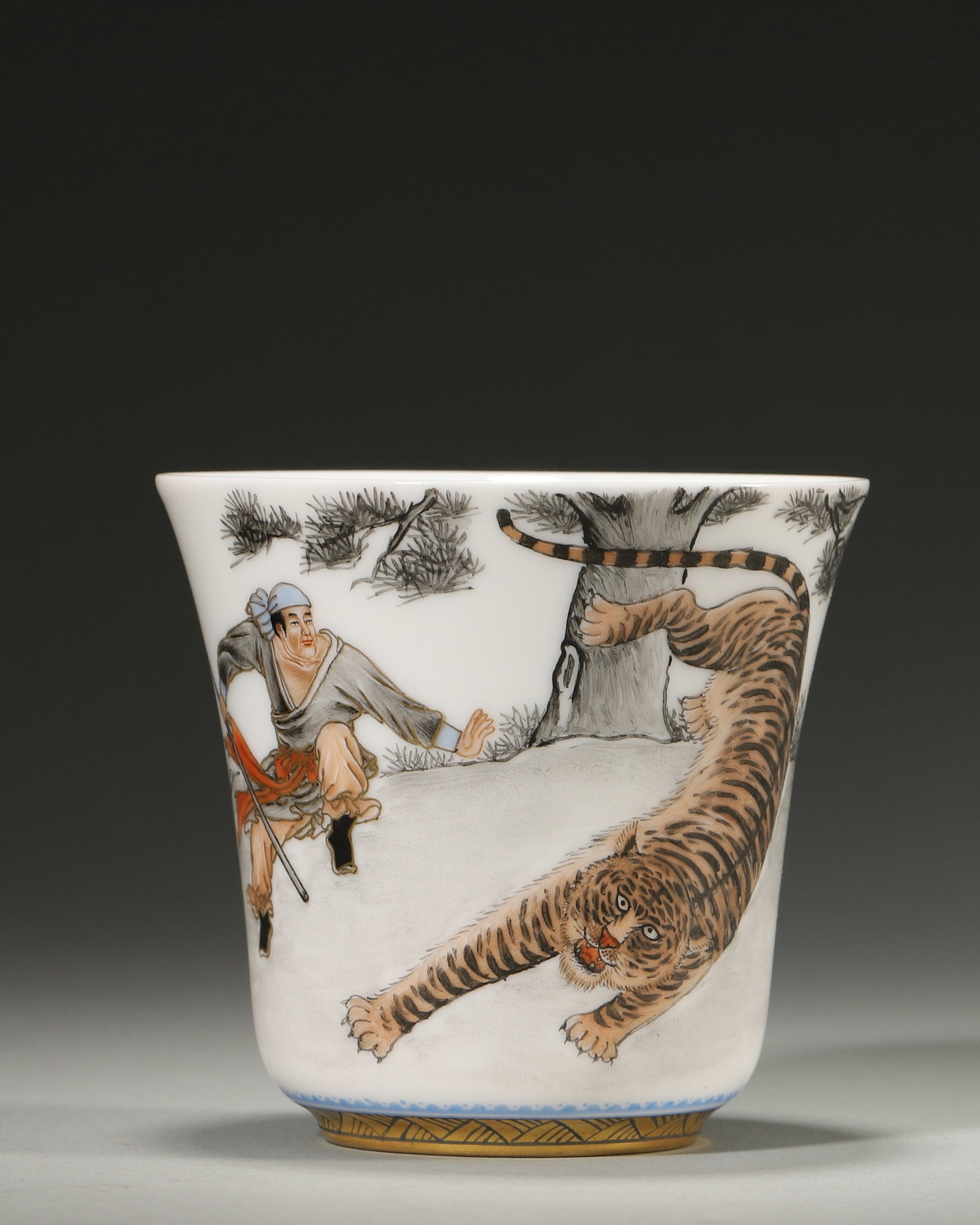 A FAMILLE-ROSE 'WU SONG FIGHTING THE TIGER' BELL-FORM CUP: A famille-rose porcelain bell-form cup painted with Wu Song fighting a tiger, with a poem inscription and seal to the reverse and a gilt foot rim. Diam. 7.8 cm; Ht. 7.6 cm; Wt. 80 g.