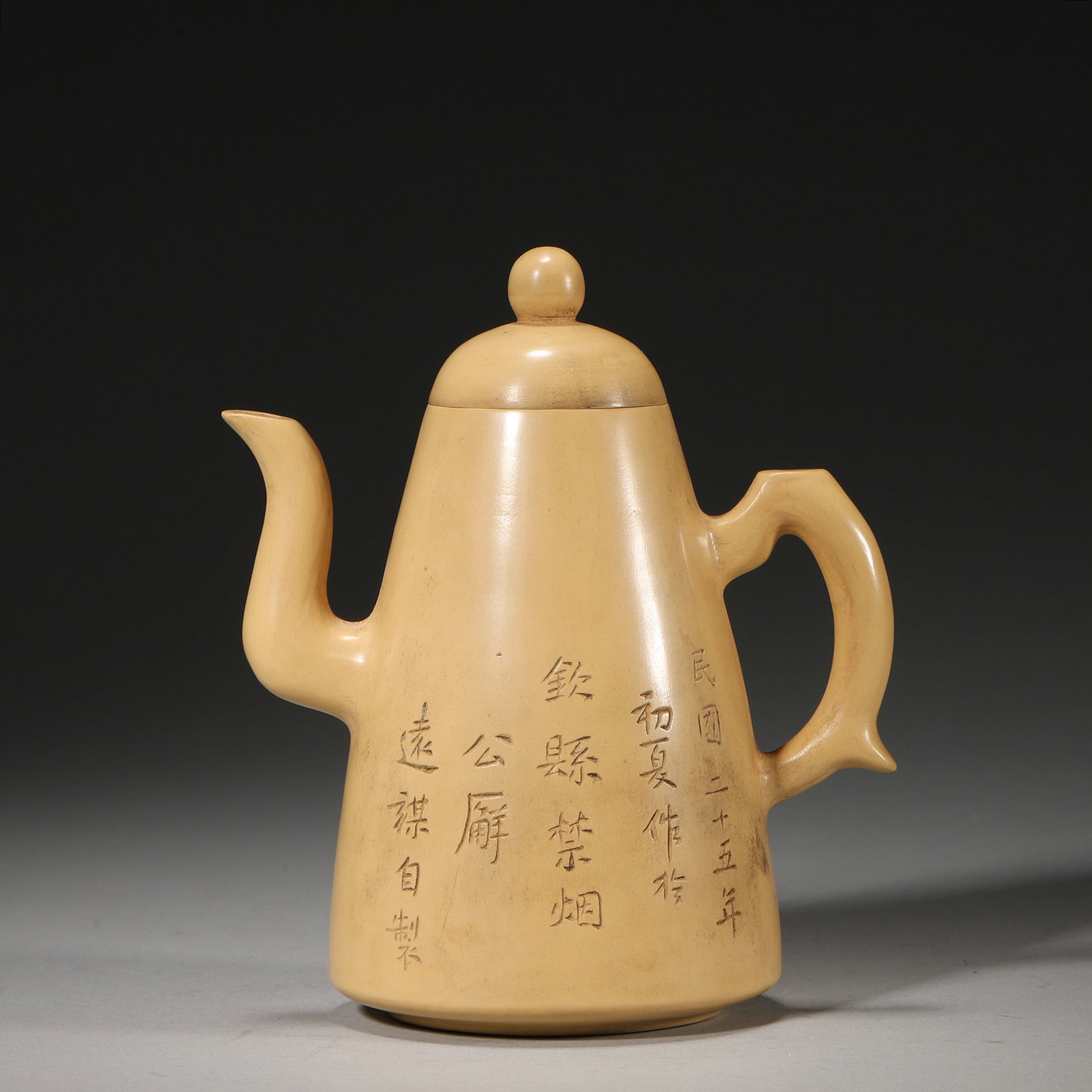 A DUANNI ZISHA TEAPOT WITH FLORAL AND INSCRIPTION DECORATION: A duanni zisha teapot with a tall conical body, bead-form finial, curved spout and fish-tail-form handle, carved with a floral still life and inscriptions. One inscription ends 'Yuanmou Zizhi'. L. 11.