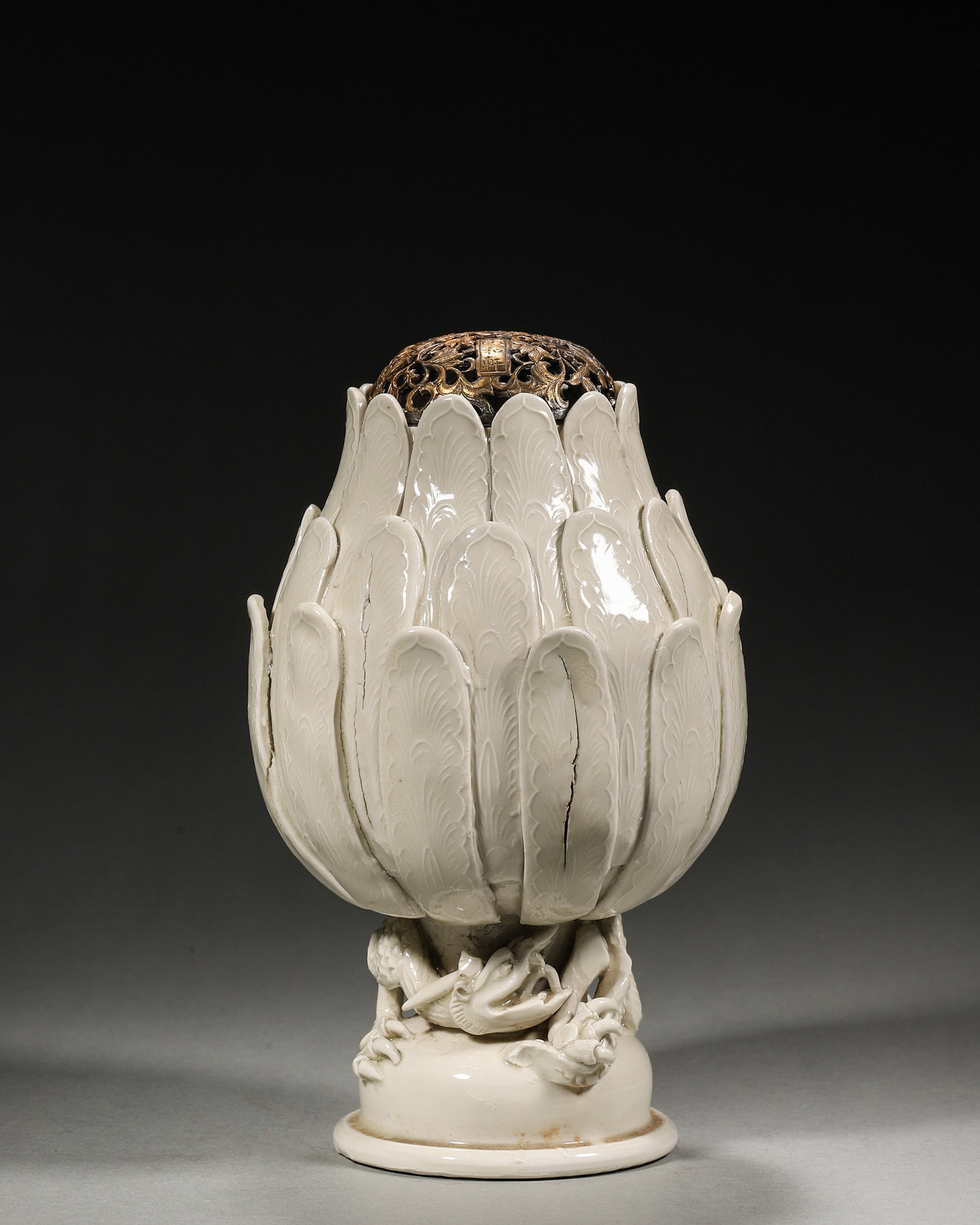 A WHITE-GLAZED 'LOTUS AND DRAGON' CENSER WITH GILT-BRONZE OPENWORK COVER: A white-glazed porcelain censer molded with overlapping lotus petals and a supporting dragon, fitted with a gilt-bronze openwork cover decorated with butterfly and flower motifs. The censer bears a