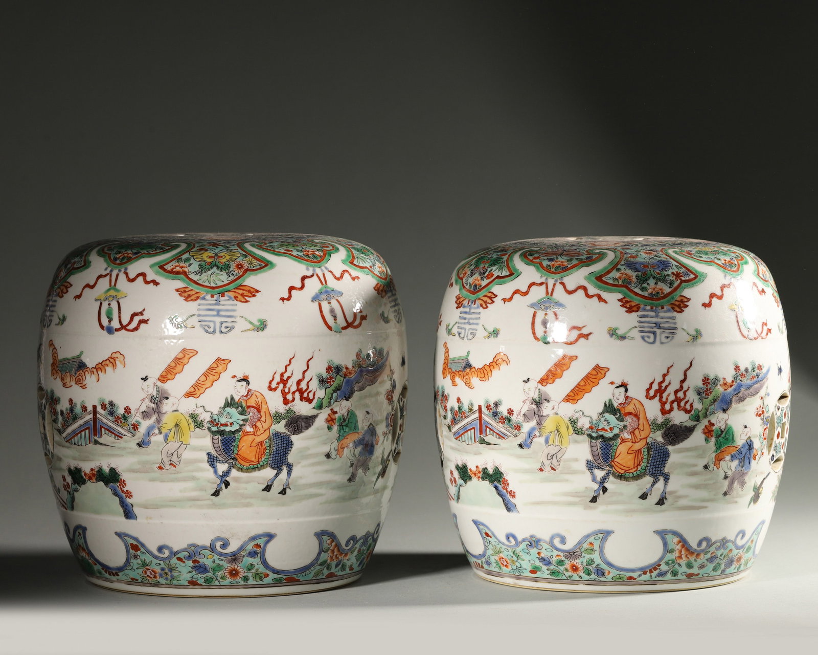 A PAIR OF FAMILLE-ROSE 'QILIN AND FIGURES' PORCELAIN STOOLS: A pair of famille-rose porcelain stools decorated with qilin and figural scenes. Diam. 23 cm; Ht. 22 cm.