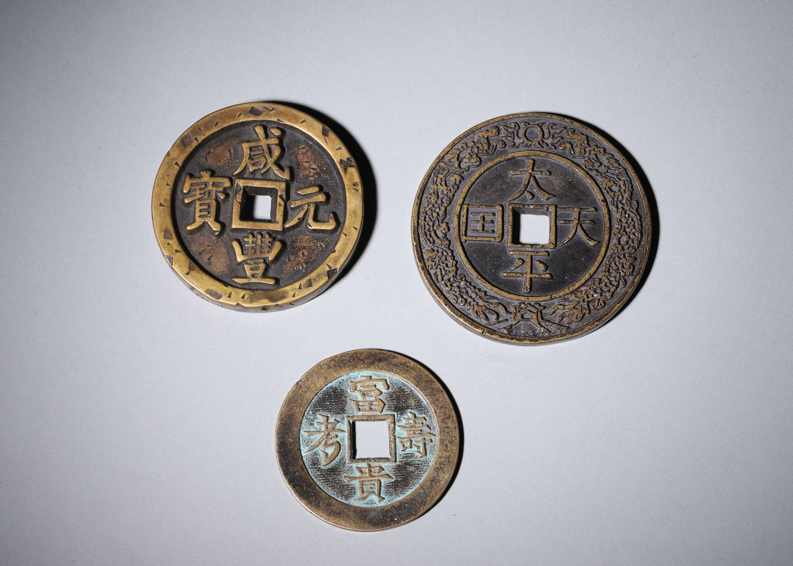 A SET OF THREE BRONZE COINS AND CHARMS (1 of 8)