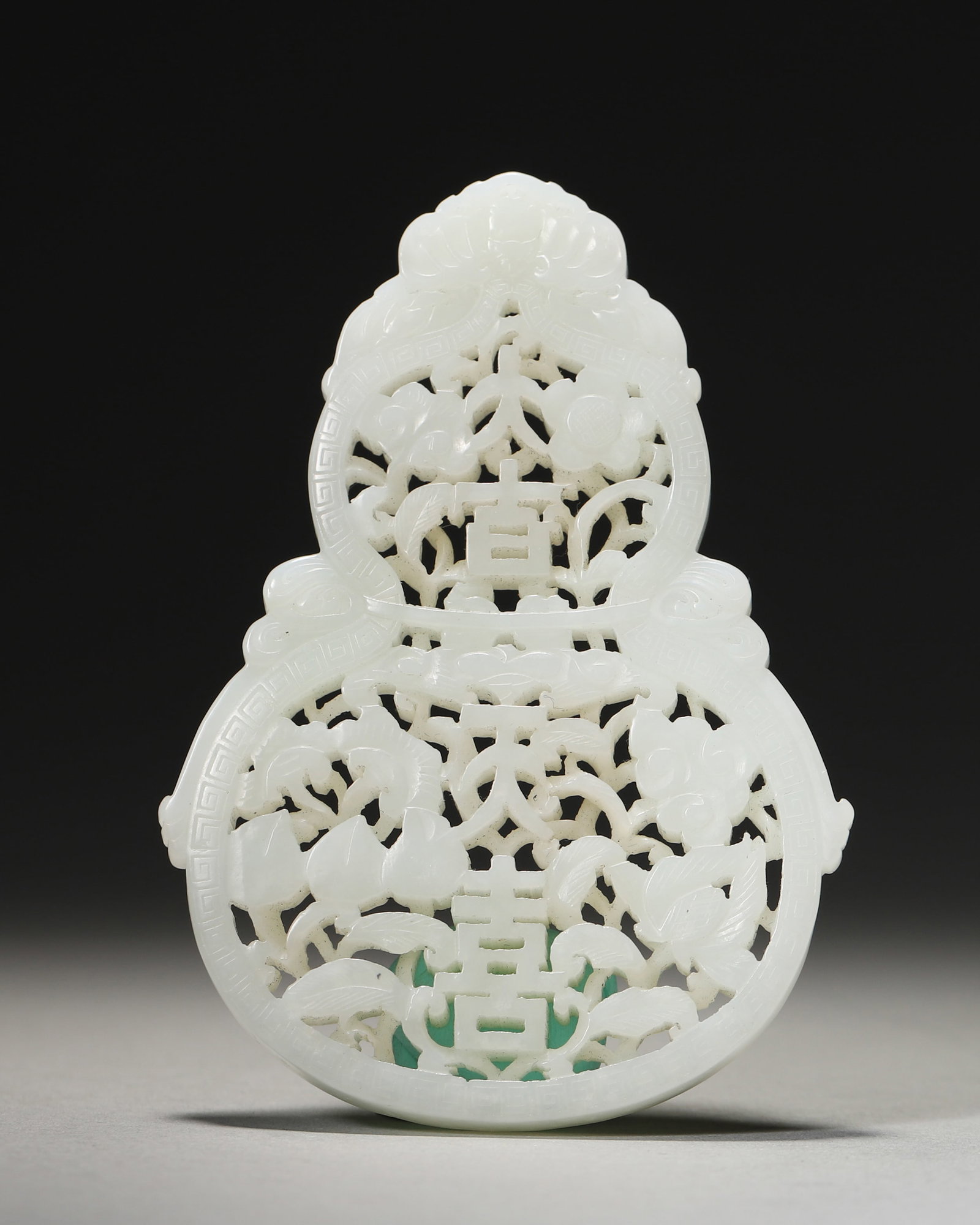 A JADE OPENWORK AUSPICIOUS PENDANT: A jade openwork pendant with auspicious characters and motifs. W. 6.3 cm; Ht. 8.8 cm; Wt. 53 g.