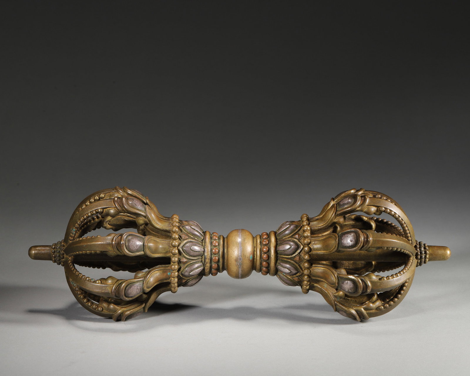 A SILVER-INLAID GILT-COPPER-ALLOY NINE-PRONGED VAJRA (1 of 7)