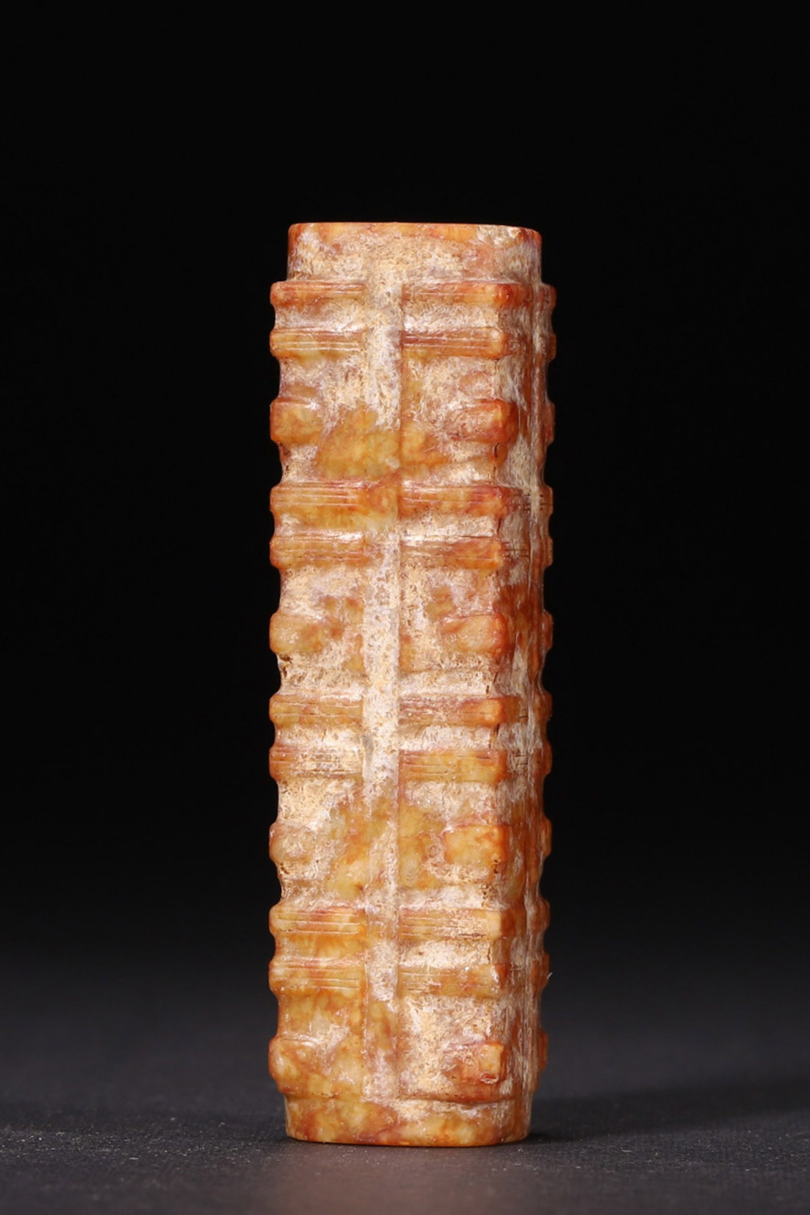 A JADE CONG-FORM PENDANT, LIANGZHU CULTURE: A jade pendant of cong form, divided into multiple sections and pierced with a central hole, with reddish surface patination. W. 1.5 cm; Ht. 6 cm; Wt. 45 g. Note: By repute, associated with Liangzhu