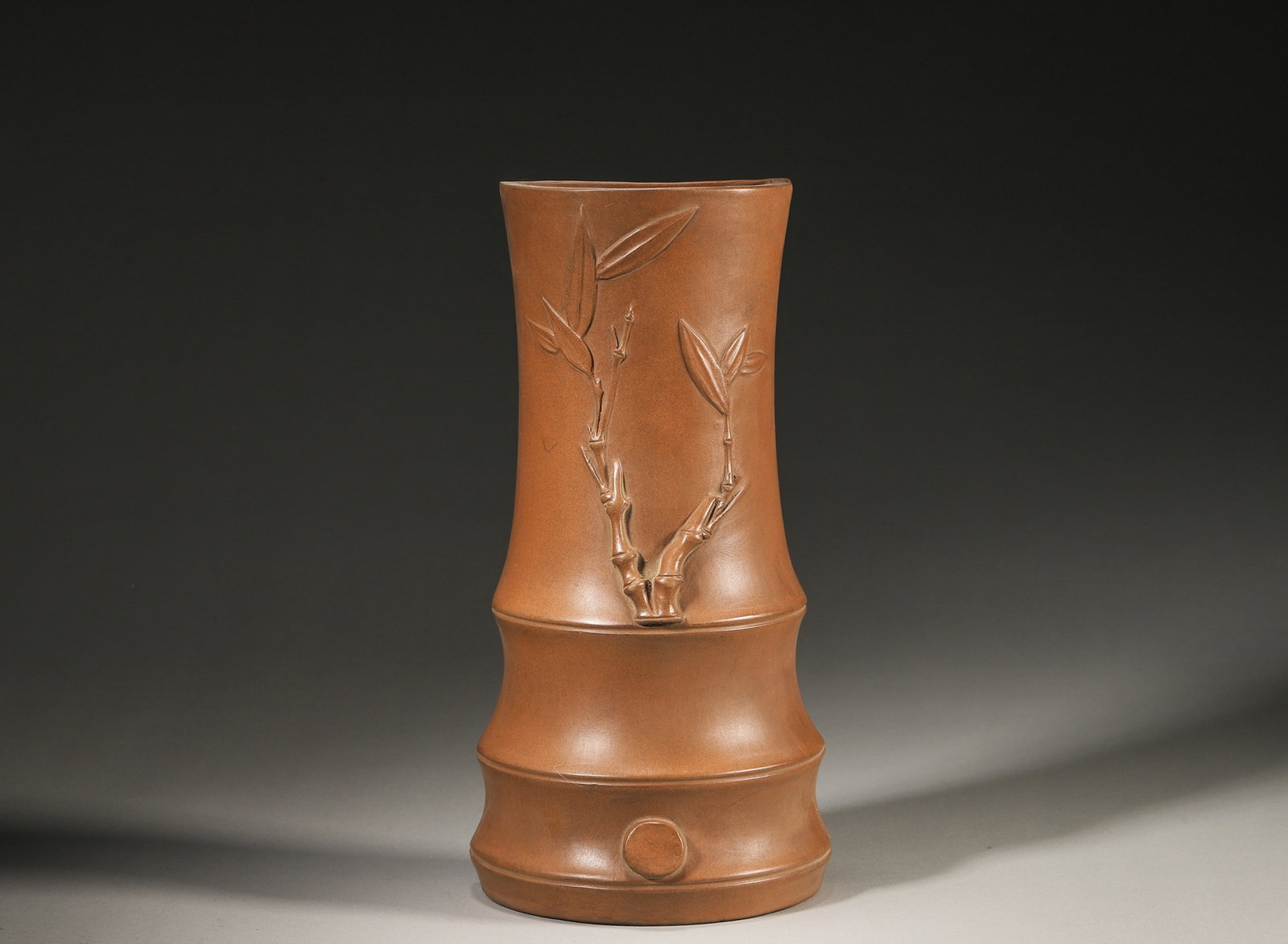 A ZISHA BAMBOO-FORM WALL VASE: A zisha wall vase modeled as bamboo segments with applied bamboo branches and leaves, with a hanging aperture to the reverse. L. 23 cm; Ht. 10 cm.