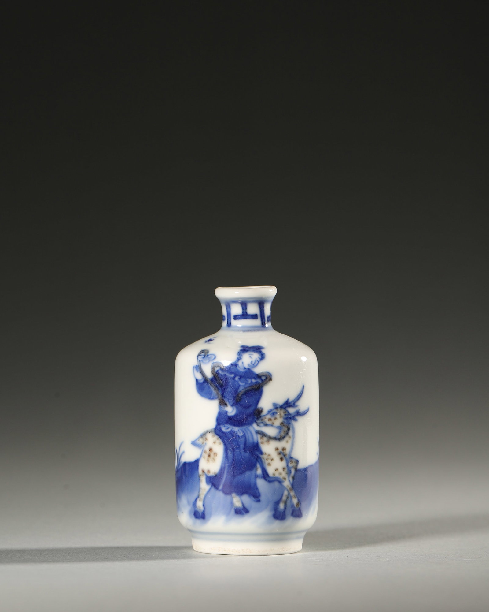 A BLUE-AND-WHITE FIGURAL PORCELAIN SNUFF BOTTLE: A blue-and-white porcelain snuff bottle decorated with a figural scene. Diam. 4.3 cm; Ht. 7 cm.