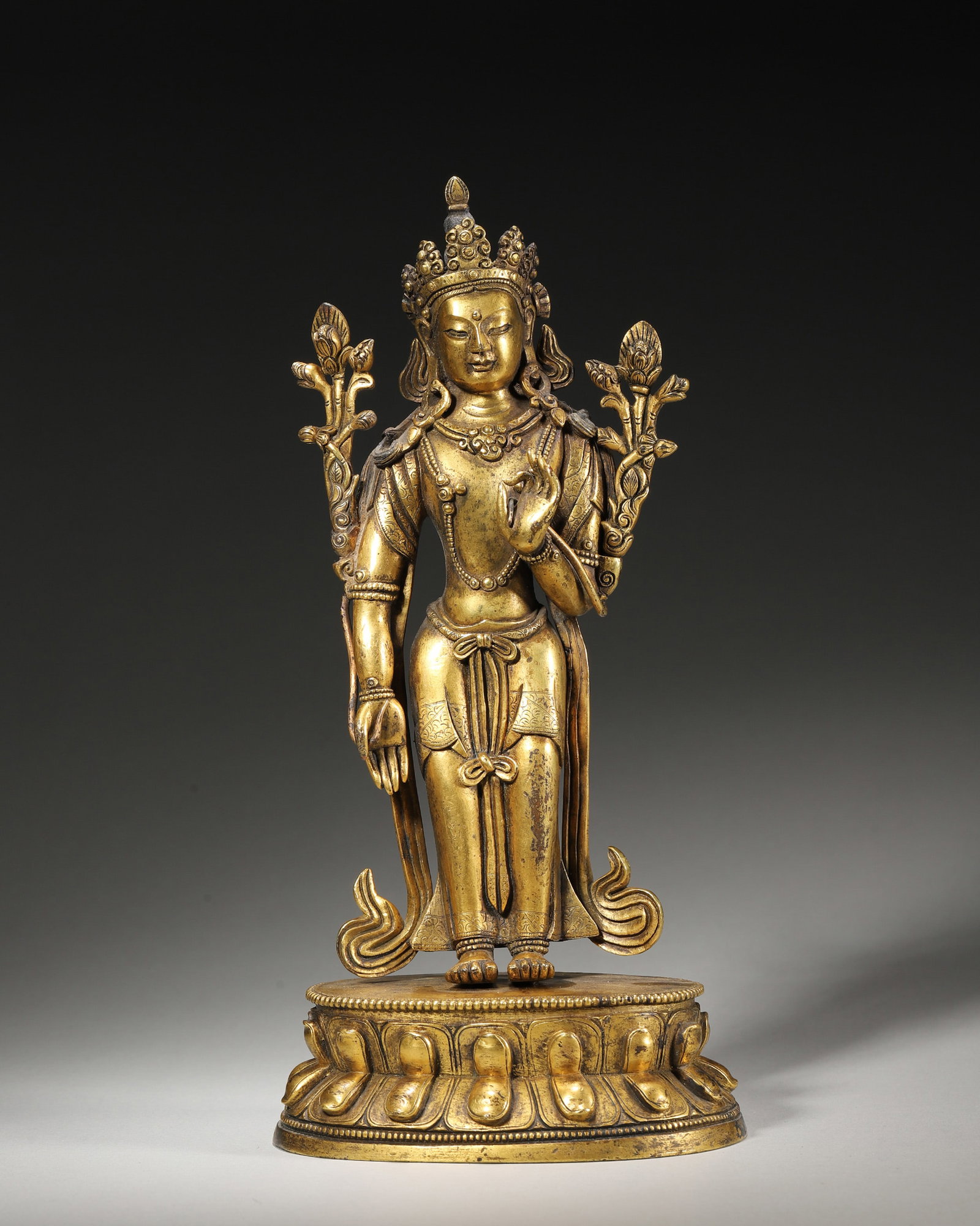 A GILT-BRONZE STANDING FIGURE OF GUANYIN: A gilt-bronze standing figure of Guanyin. W. 10.5 cm; Ht. 22 cm; Wt. 1,102 g.